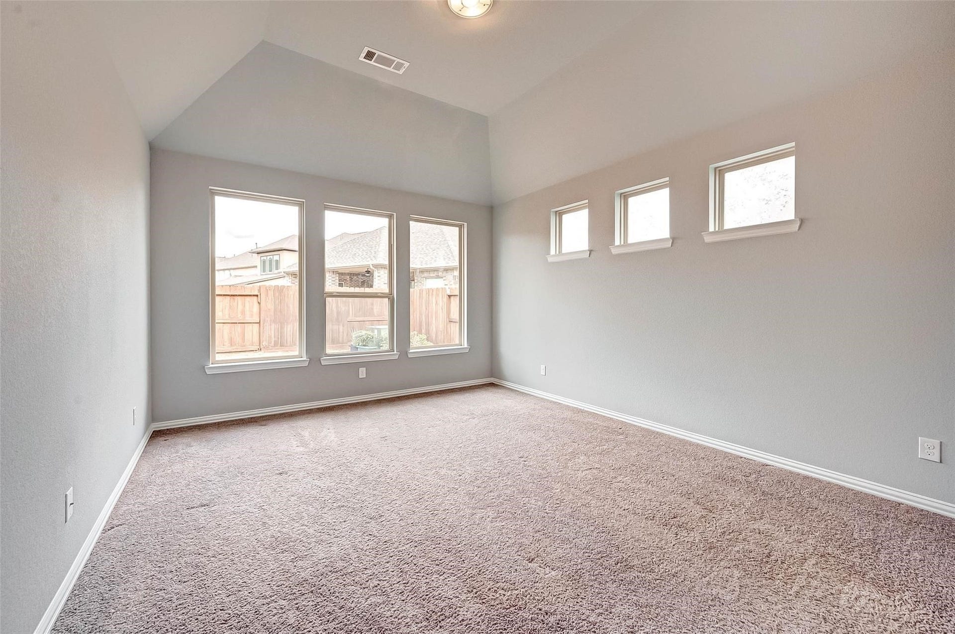 23514 San Ricci Court, Richmond, TX 77406 Spacious primary bedroom featuring vaulted ceilings and plenty of natural light.