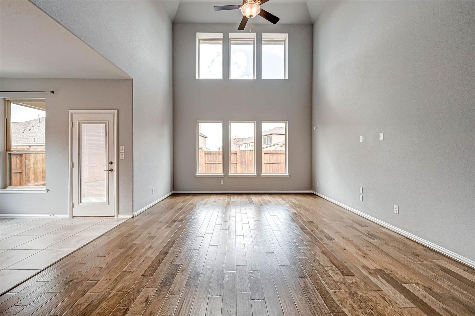 23514 San Ricci Court, Richmond, TX 77406 Another view of the living area, showcasing the soaring ceilings, large windows, and backyard access.