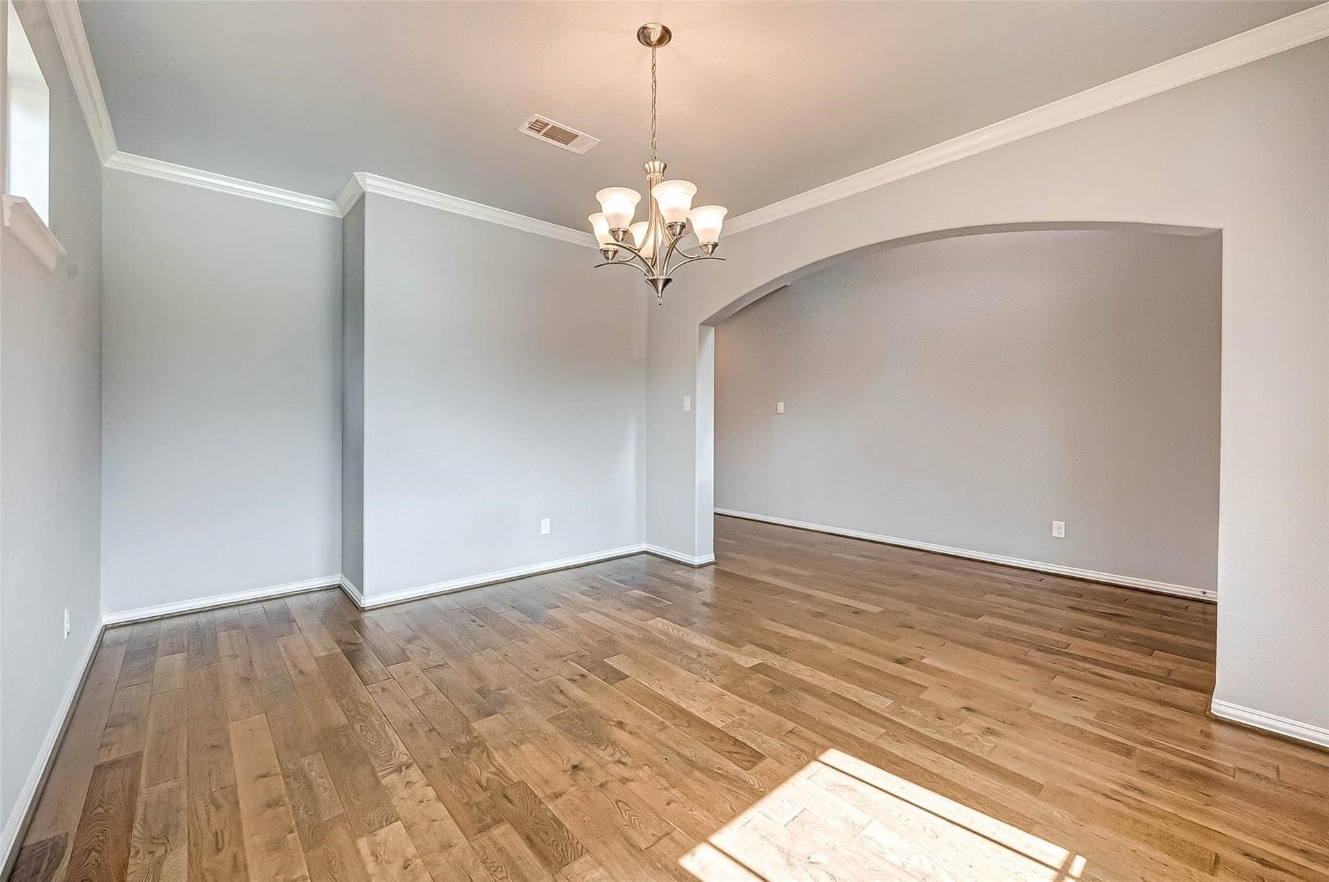 23514 San Ricci Court, Richmond, TX 77406 Another view of the formal dining area, highlighting the arched opening and wood flooring.