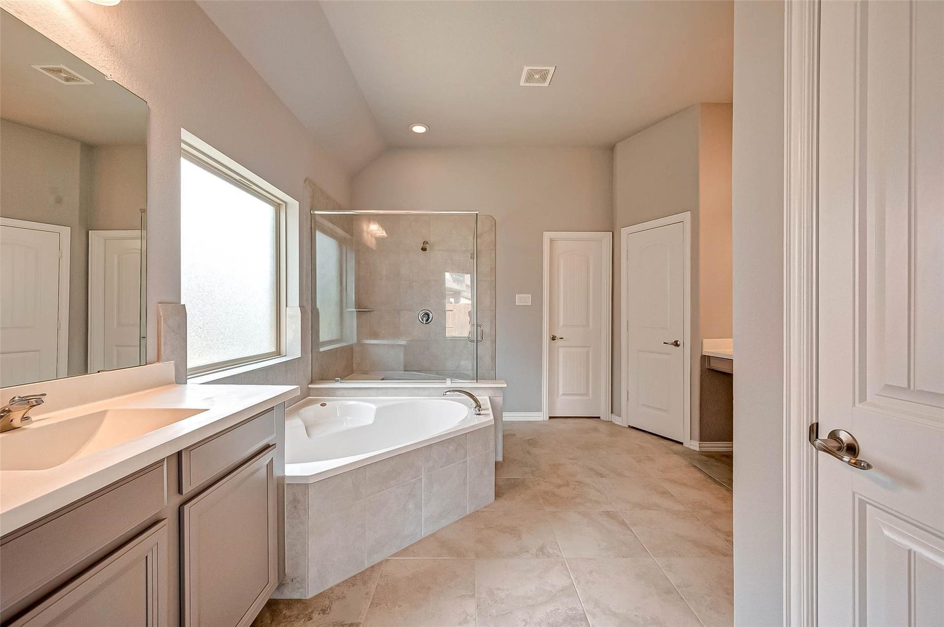 23514 San Ricci Court, Richmond, TX 77406 Primary ensuite bathroom featuring a soaking tub, separate glass-enclosed shower, and spacious vanity.