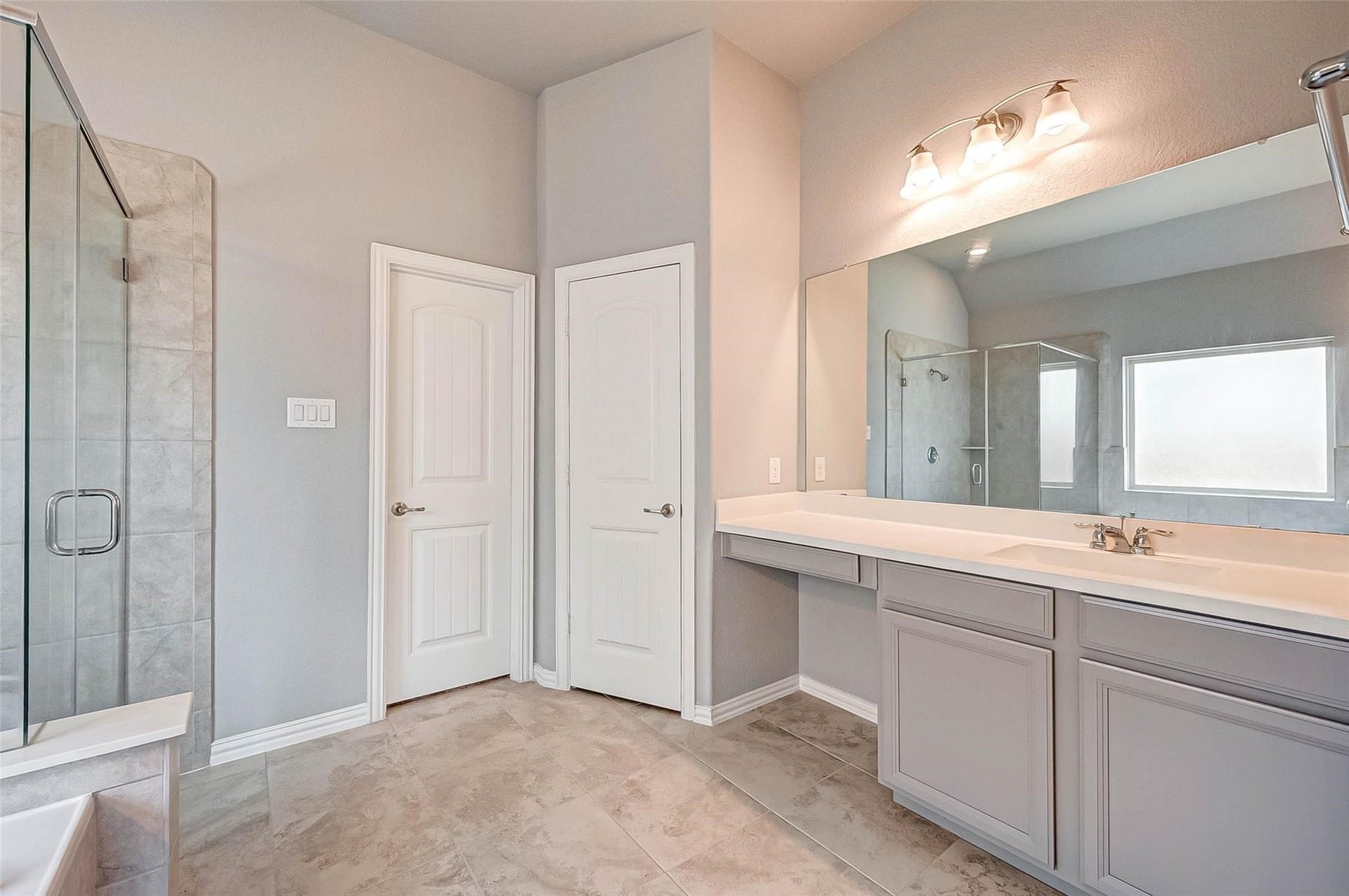 23514 San Ricci Court, Richmond, TX 77406 Another view of the primary bathroom, highlighting the spacious vanity and separate glass-enclosed shower.