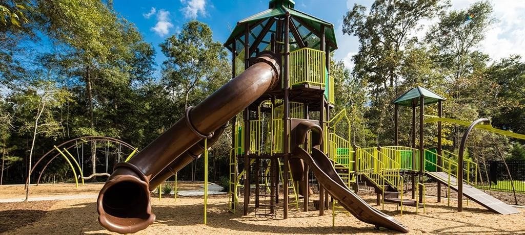 23705 Pagliano Court, New Caney, TX 77357 Explore endless fun at this vibrant community playground, featuring multiple slides, climbing structures, and lush surroundings for family enjoyment.
