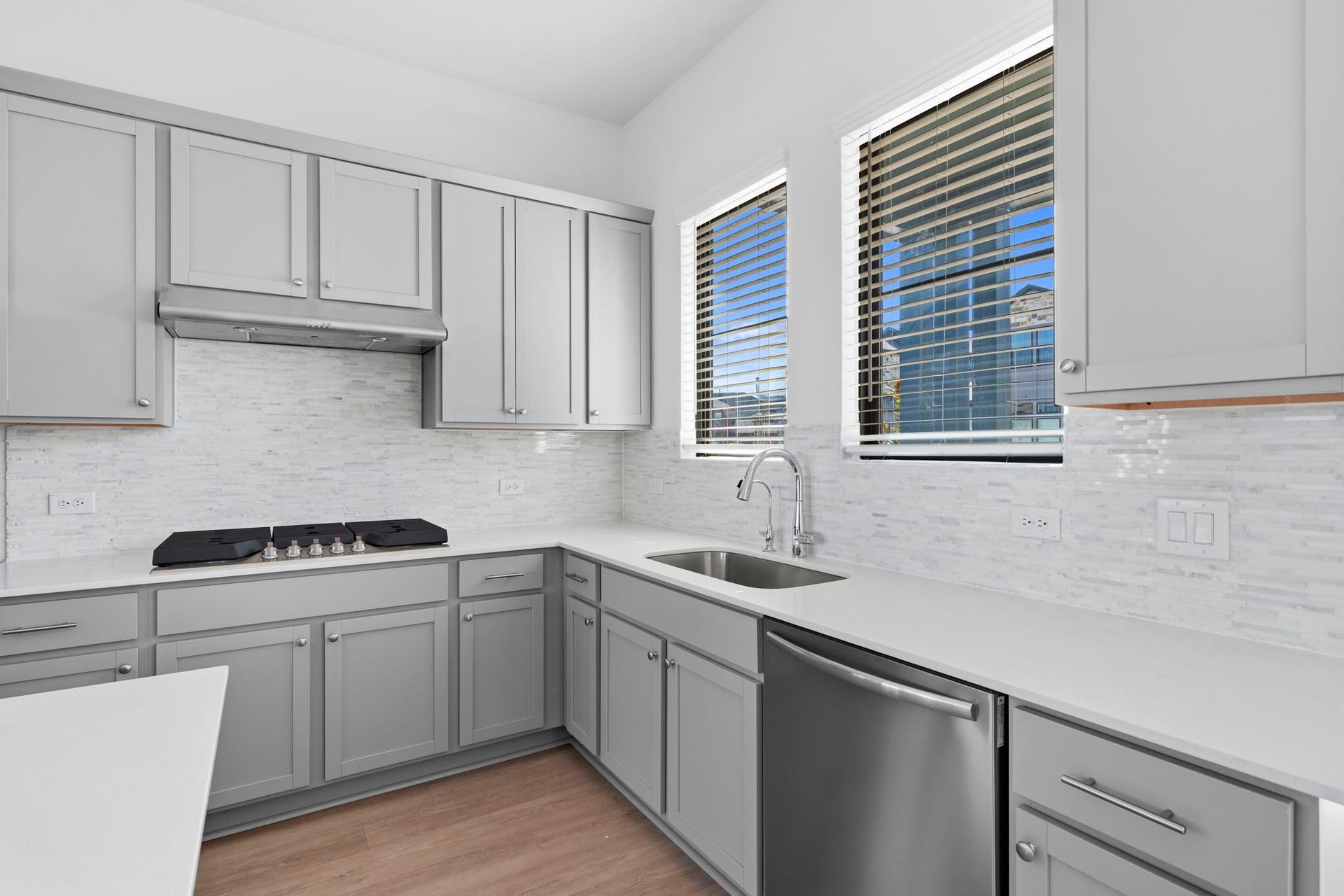 3317 City Heart Avenue, Richmond, TX 77406 Welcome to a kitchen designed to feel bright, polished, and effortlessly functional. Soft grey cabinetry pairs beautifully with the light backsplash and quartz countertops, while the windows above the sink bring in natural light and create a refreshing connection to the outdoors.