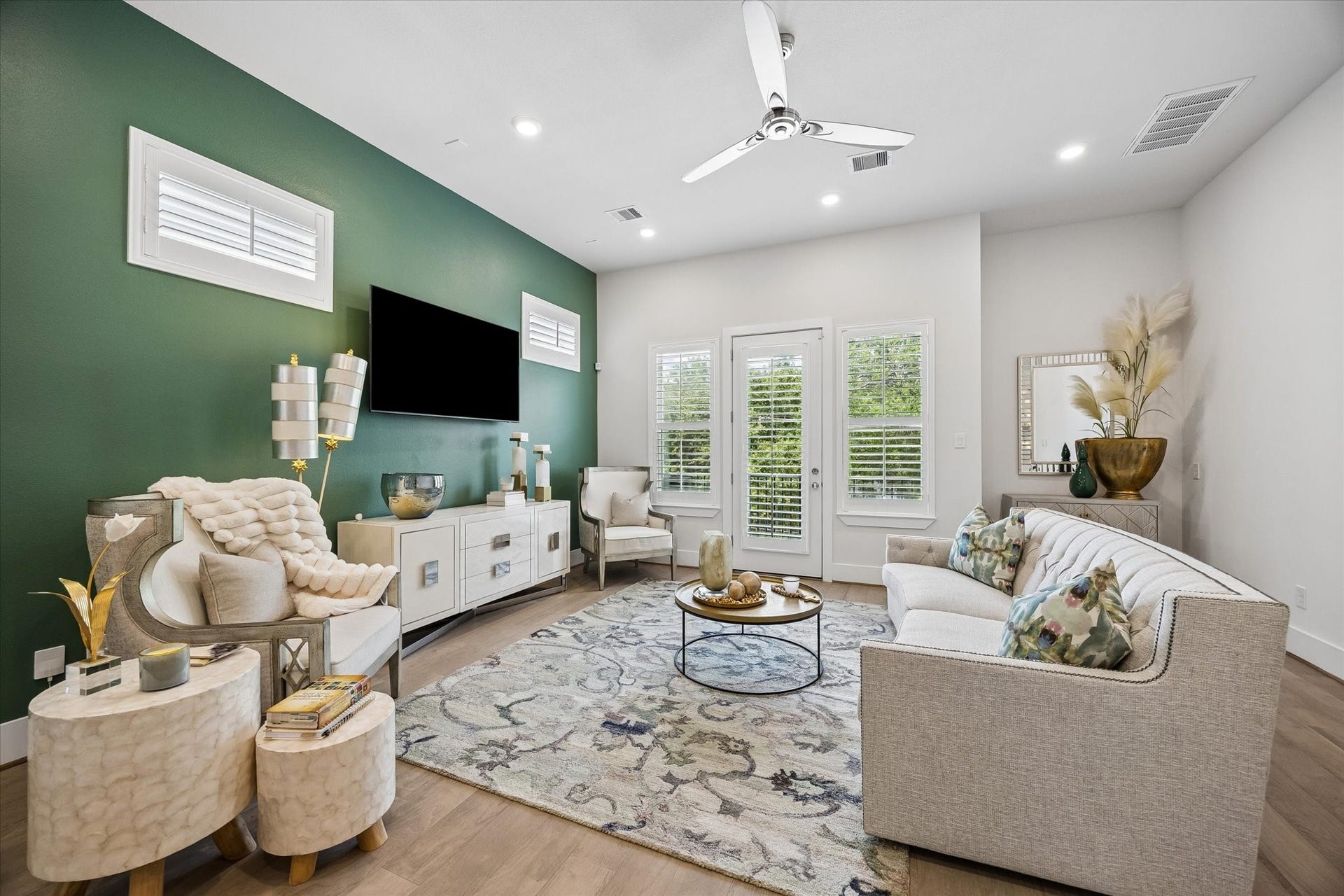 1226 W 21st Street, Houston, TX 77008 The main-floor living area feels bright and inviting with engineered wood flooring, recessed lighting, wood shuttered windows, balcony access, and a bold designer accent wall that gives the space a stylish, memorable feel.
