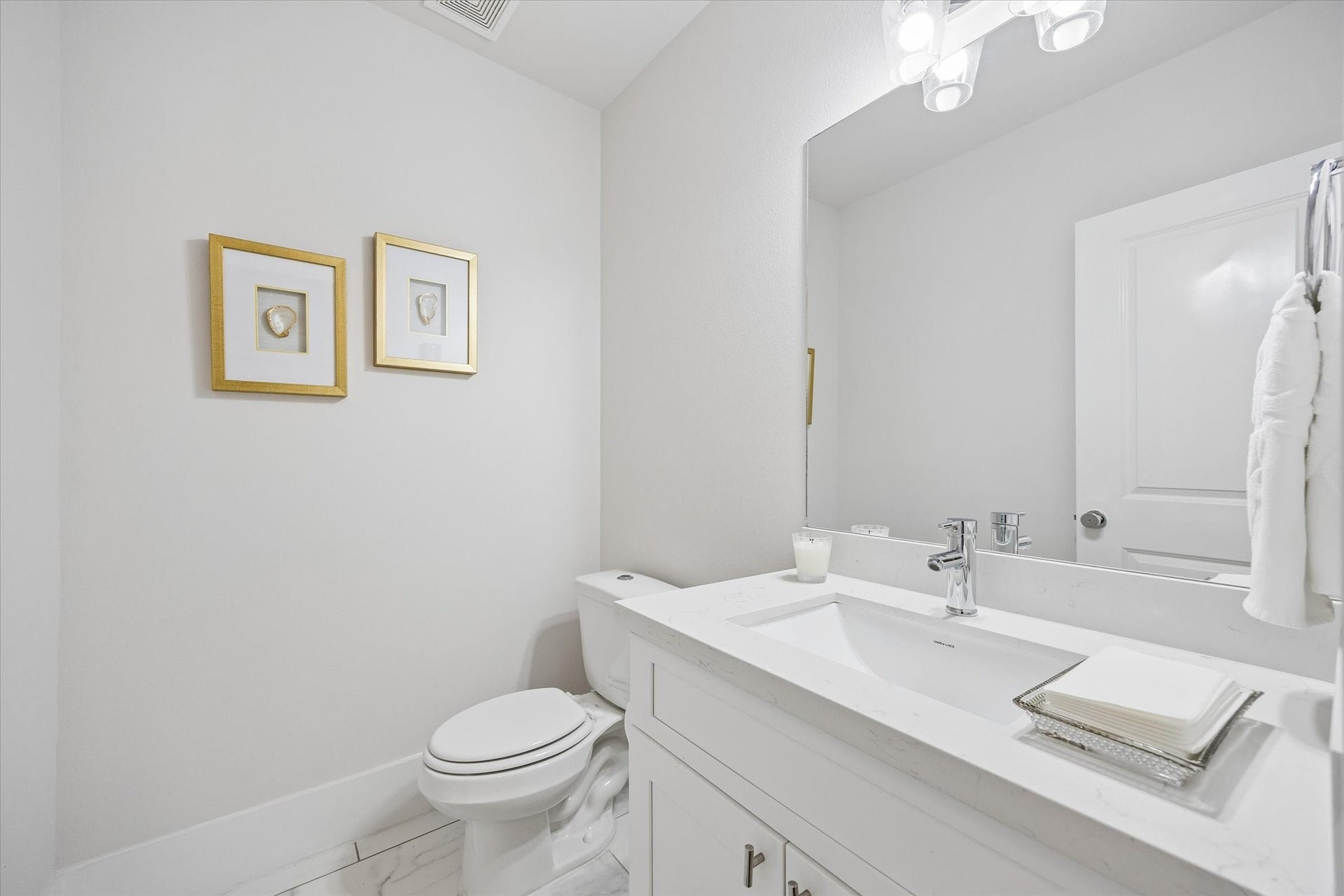 1226 W 21st Street, Houston, TX 77008 The main floor powder bath is perfect for guests and daily use with crisp, clean finishes, a sleek vanity, designer lighting, and a polished look that feels fresh and easy to maintain.
