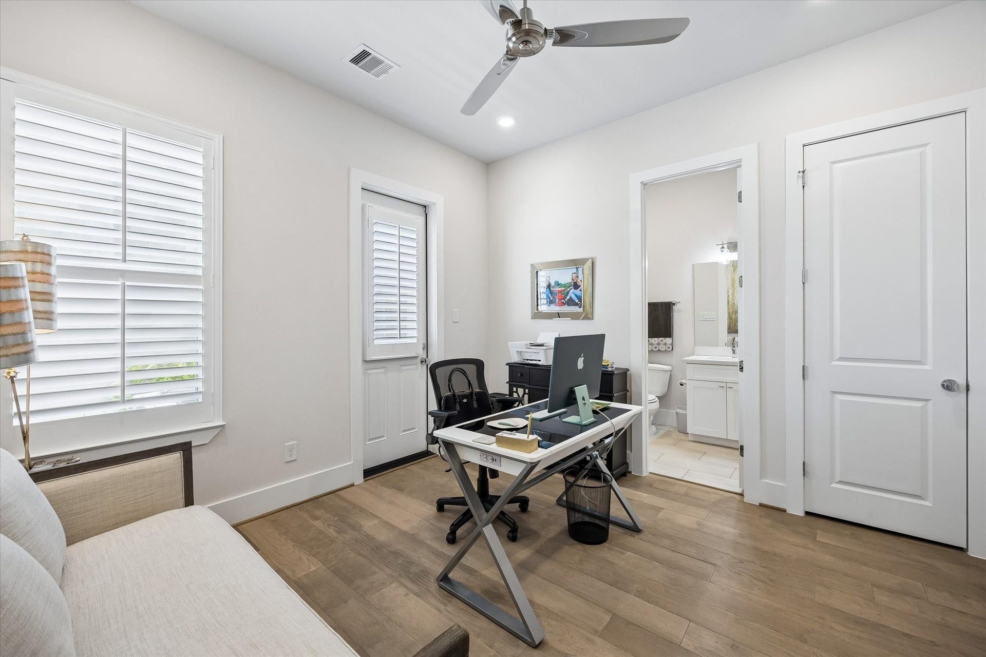 1226 W 21st Street, Houston, TX 77008 This first-floor guest suite offers a comfortable private retreat with engineered wood flooring, wood shuttered windows, a charming cottage-style door to the back deck and small fenced area, a walk-in closet, and its own ensuite bath for everyday ease.