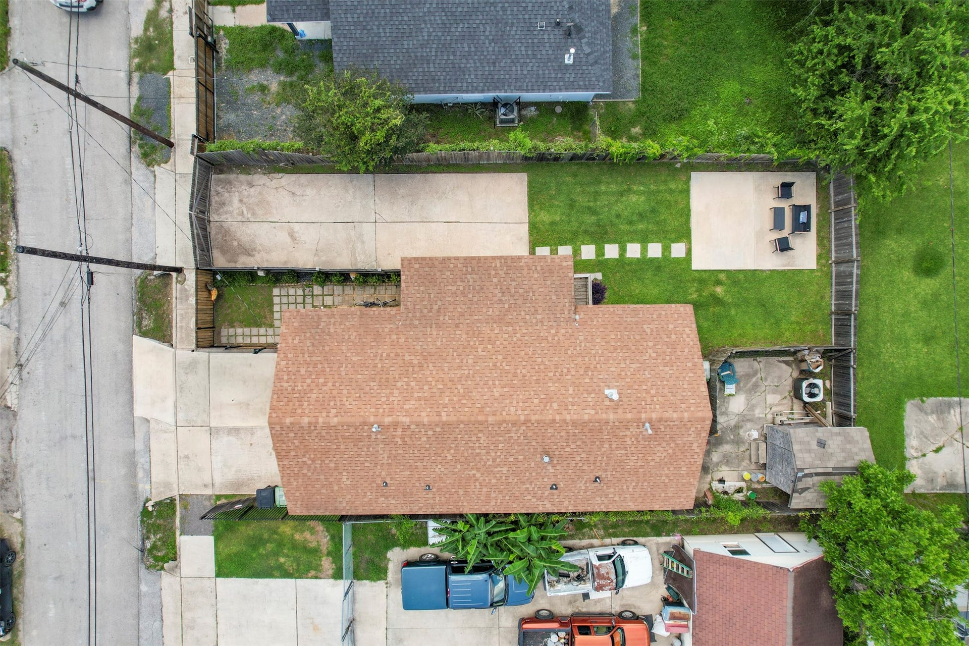 1121 Panama Street, #B, Houston, TX 77009 Straight-down aerial of the property showing the full footprint, concrete driveway, fully fenced backyard, dedicated patio slab, and stepping stone pathway.