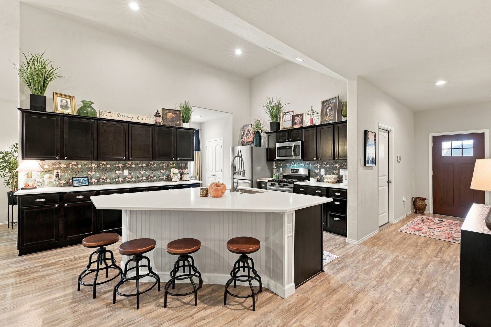 11371 Dawn Beach Lane, Conroe, TX 77304 Spacious kitchen with elegant dark cabinetry and modern stainless steel appliances. The large island offers ample seating, making it perfect for entertaining. Warm wood flooring complements the open, inviting layout.