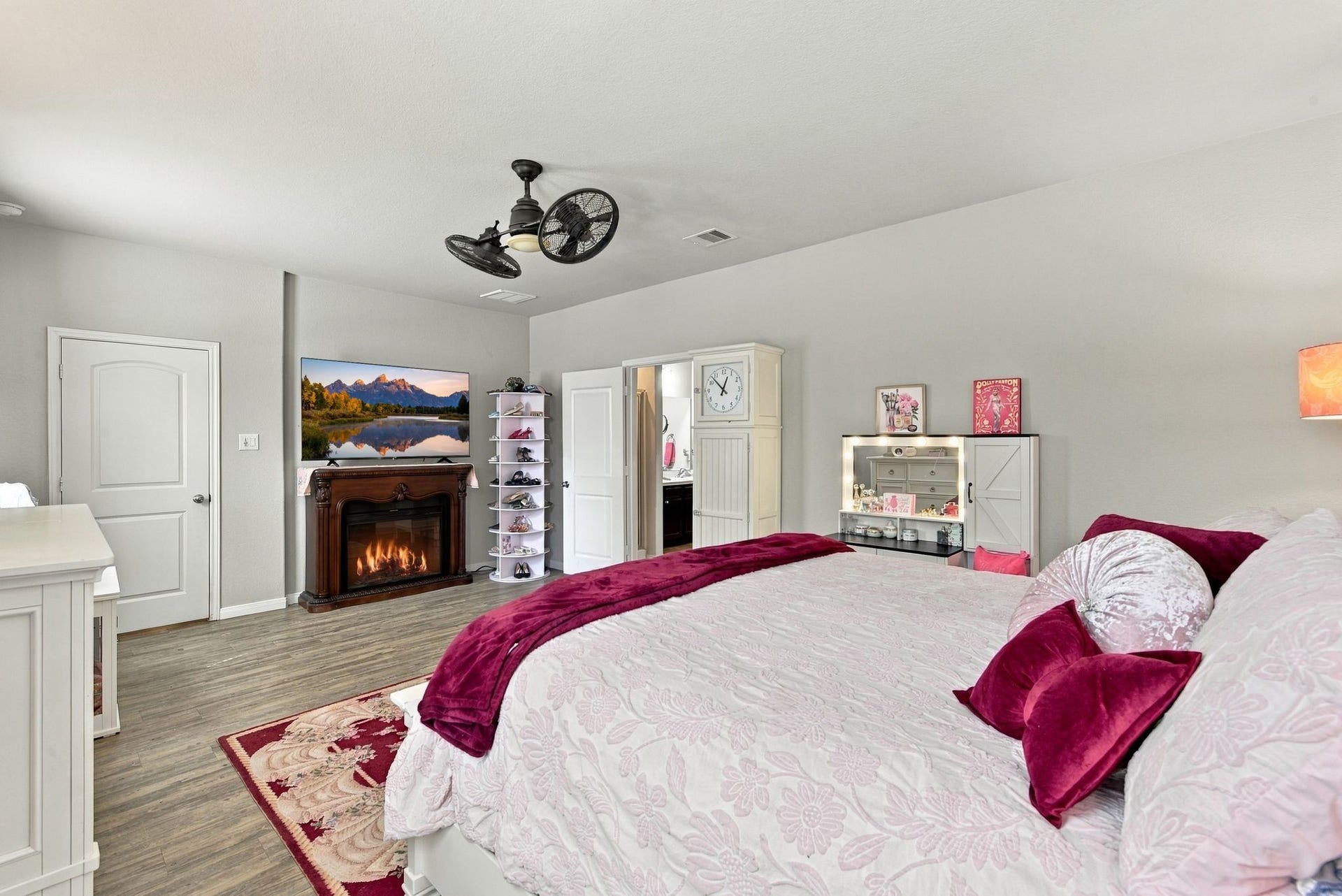 11371 Dawn Beach Lane, Conroe, TX 77304 Spacious bedroom with elegant wood flooring, featuring a cozy fireplace and a sleek ceiling fan. The room is tastefully decorated in warm tones, offering a comfortable and inviting atmosphere.
