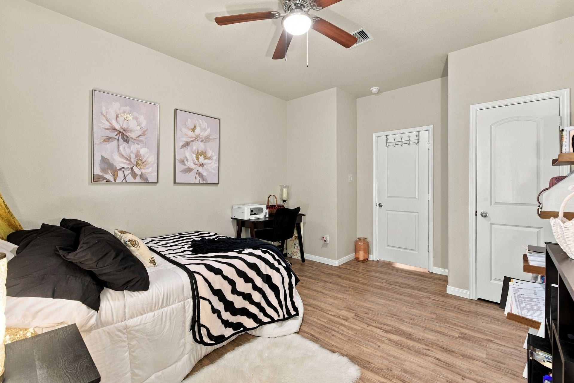 11371 Dawn Beach Lane, Conroe, TX 77304 Cozy bedroom with warm wood flooring, stylish decor, and ample natural light, featuring a ceiling fan and modern furnishings for a comfortable living space.