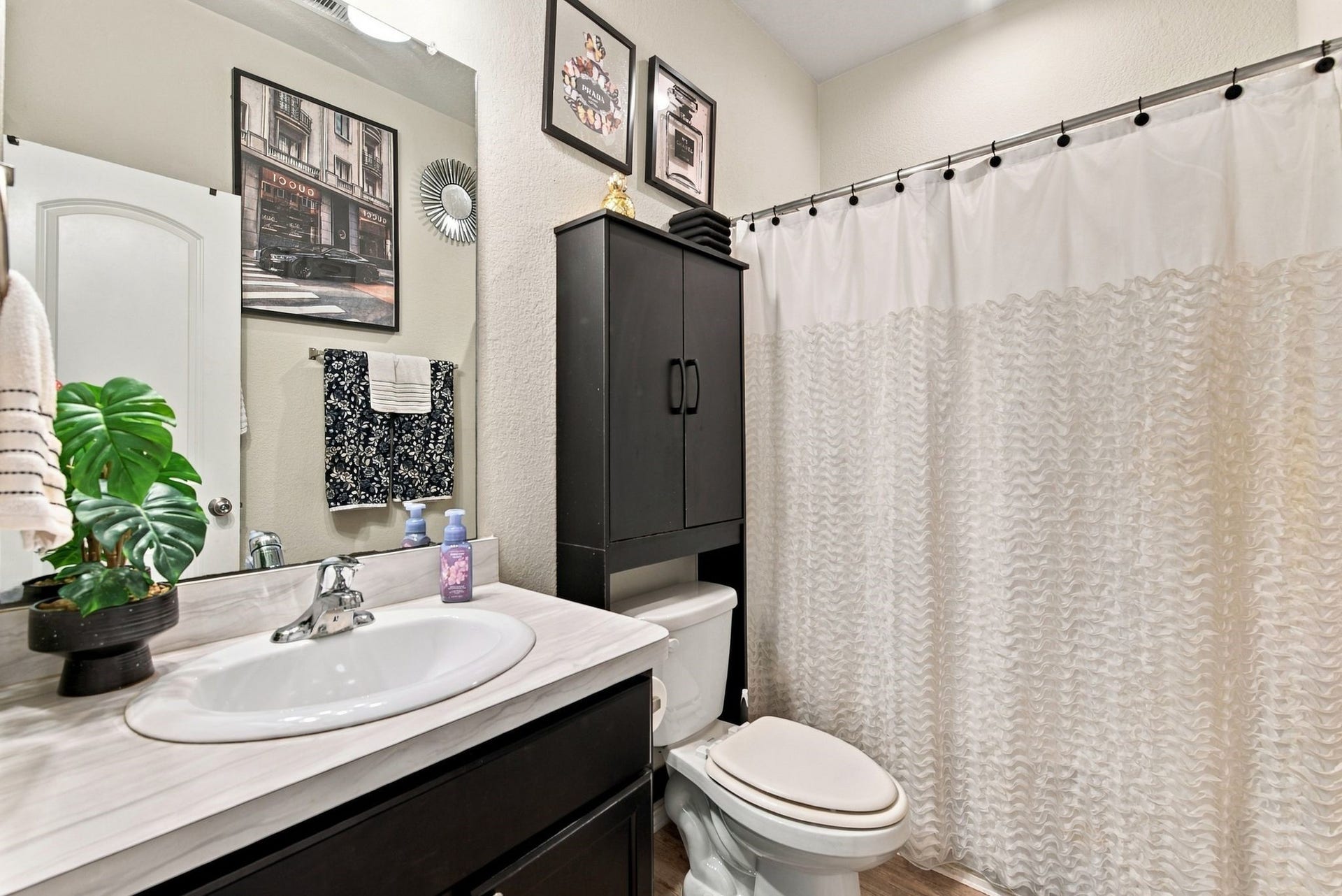 11371 Dawn Beach Lane, Conroe, TX 77304 Stylish bathroom with modern fixtures, featuring a sleek vanity, elegant wall art, and ample storage space.
