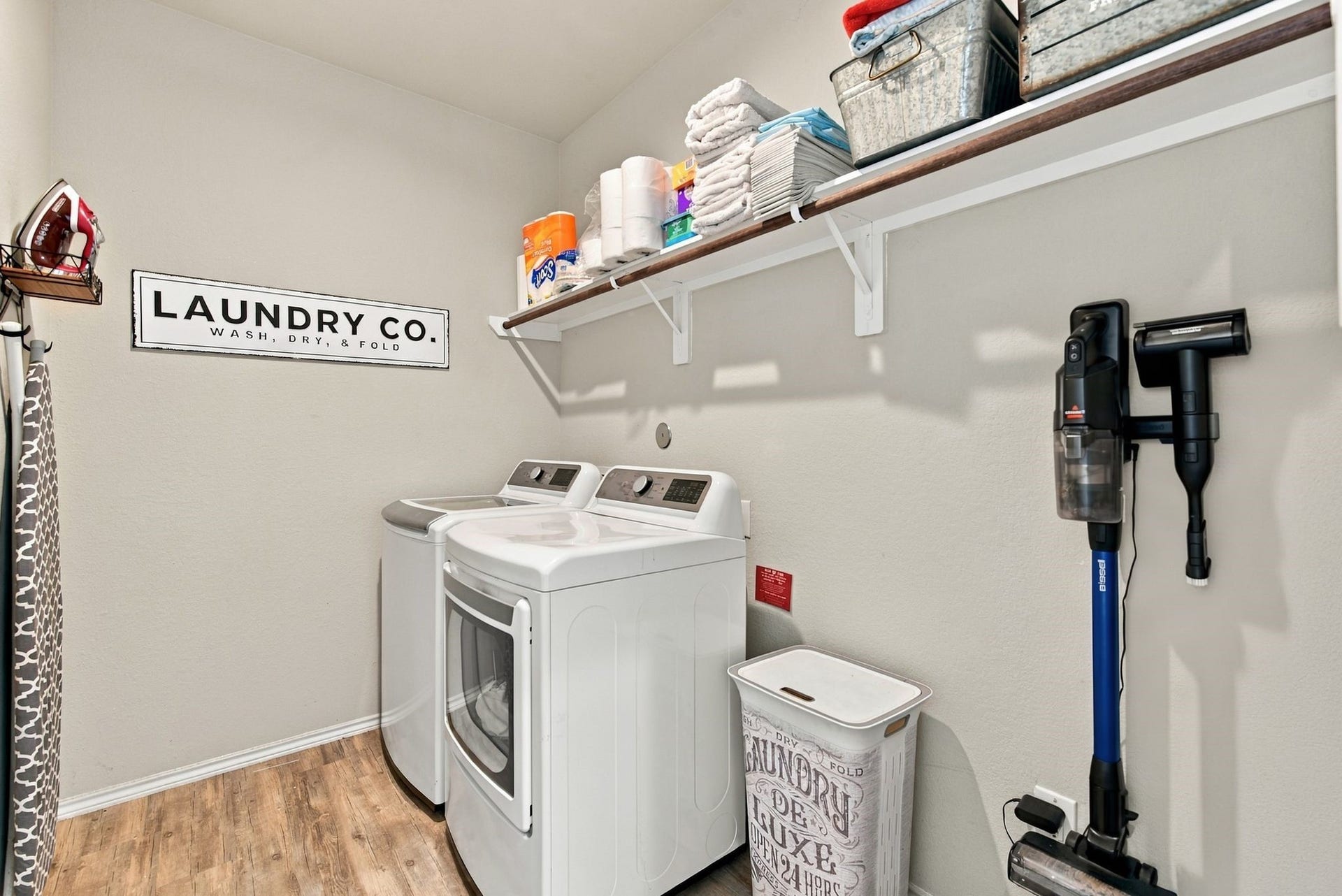 11371 Dawn Beach Lane, Conroe, TX 77304 Charming laundry room with modern appliances, ample shelving for organization, and a stylish decor accent, creating a functional and appealing space.