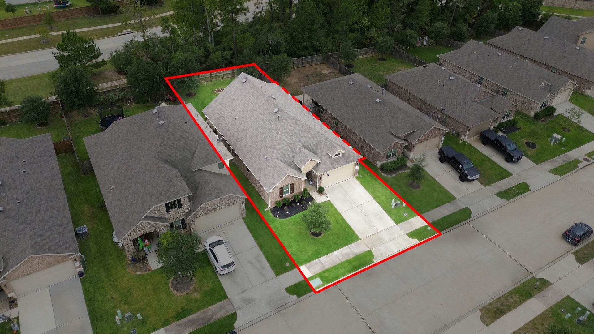 11371 Dawn Beach Lane, Conroe, TX 77304 Charming single-story home with a spacious driveway and lush green lawn, nestled in a peaceful neighborhood with tree-lined surroundings.