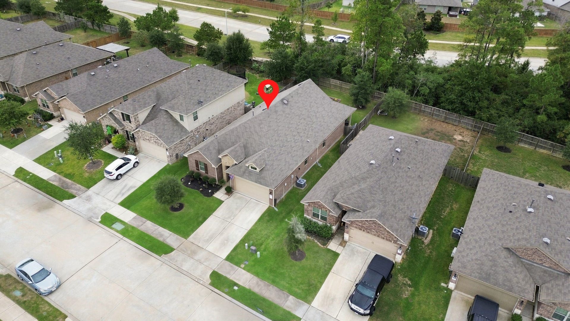 11371 Dawn Beach Lane, Conroe, TX 77304 Charming single-story home nestled in a peaceful neighborhood, featuring a spacious driveway and lush front yard, with a backdrop of mature trees providing privacy and tranquility.