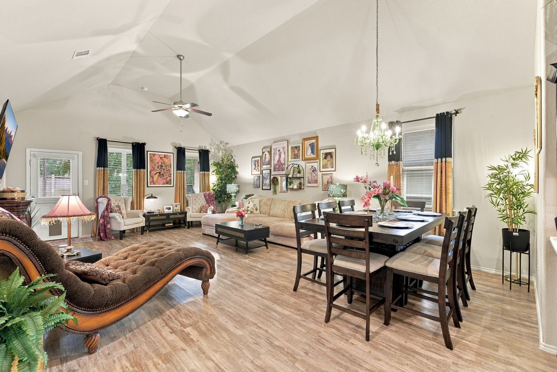 11371 Dawn Beach Lane, Conroe, TX 77304 Spacious open-concept living and dining area with elegant hardwood floors, vaulted ceilings, and abundant natural light. The room features tasteful decor, a cozy seating area, and a stylish chandelier above the dining table, perfect for entertaining.