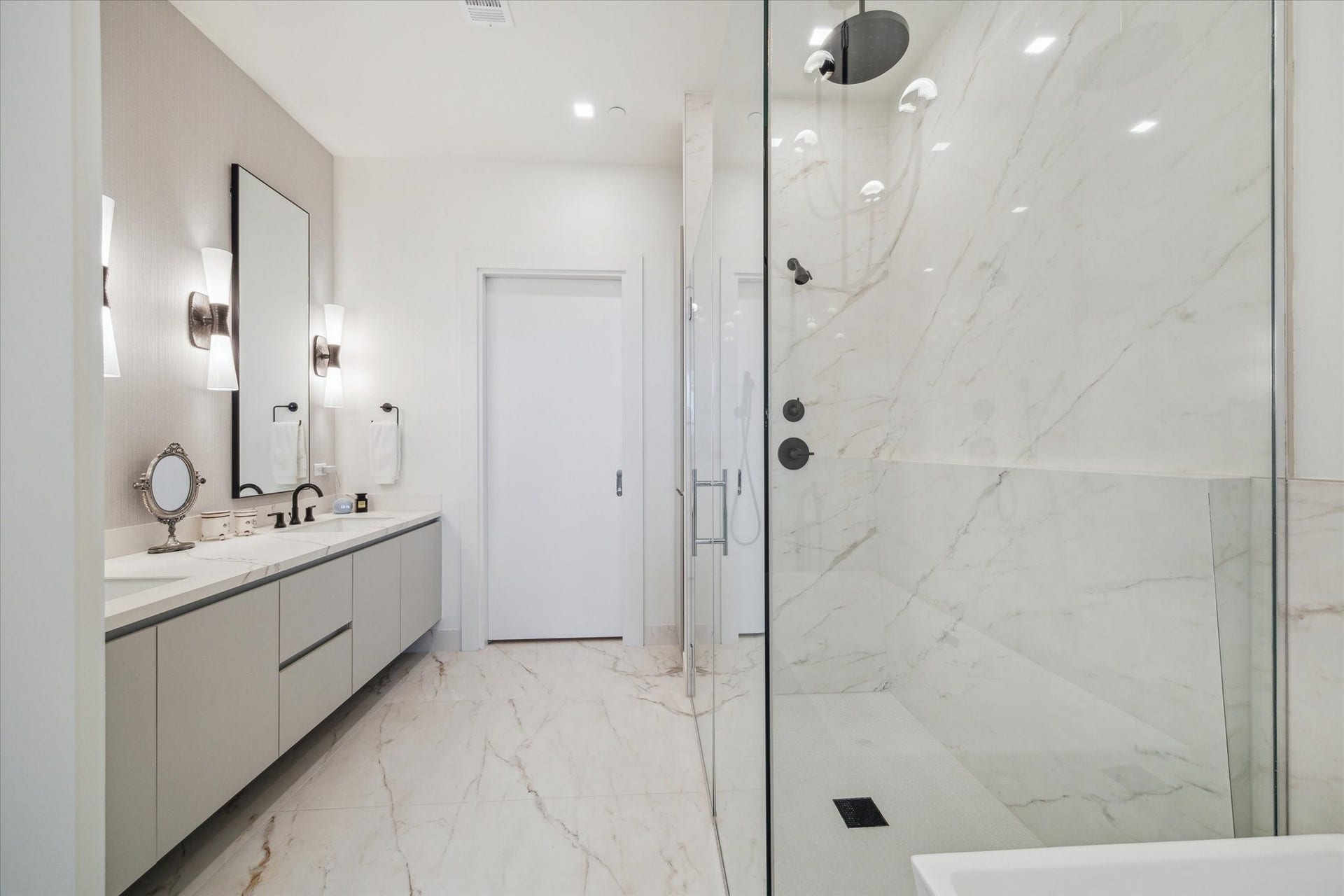 1711 Allen Parkway, #2601, Houston, TX 77019 Primary bath with curbless shower, soaking tub, wallcovering, designer lighting and mirrors. Door leads to primary closet.