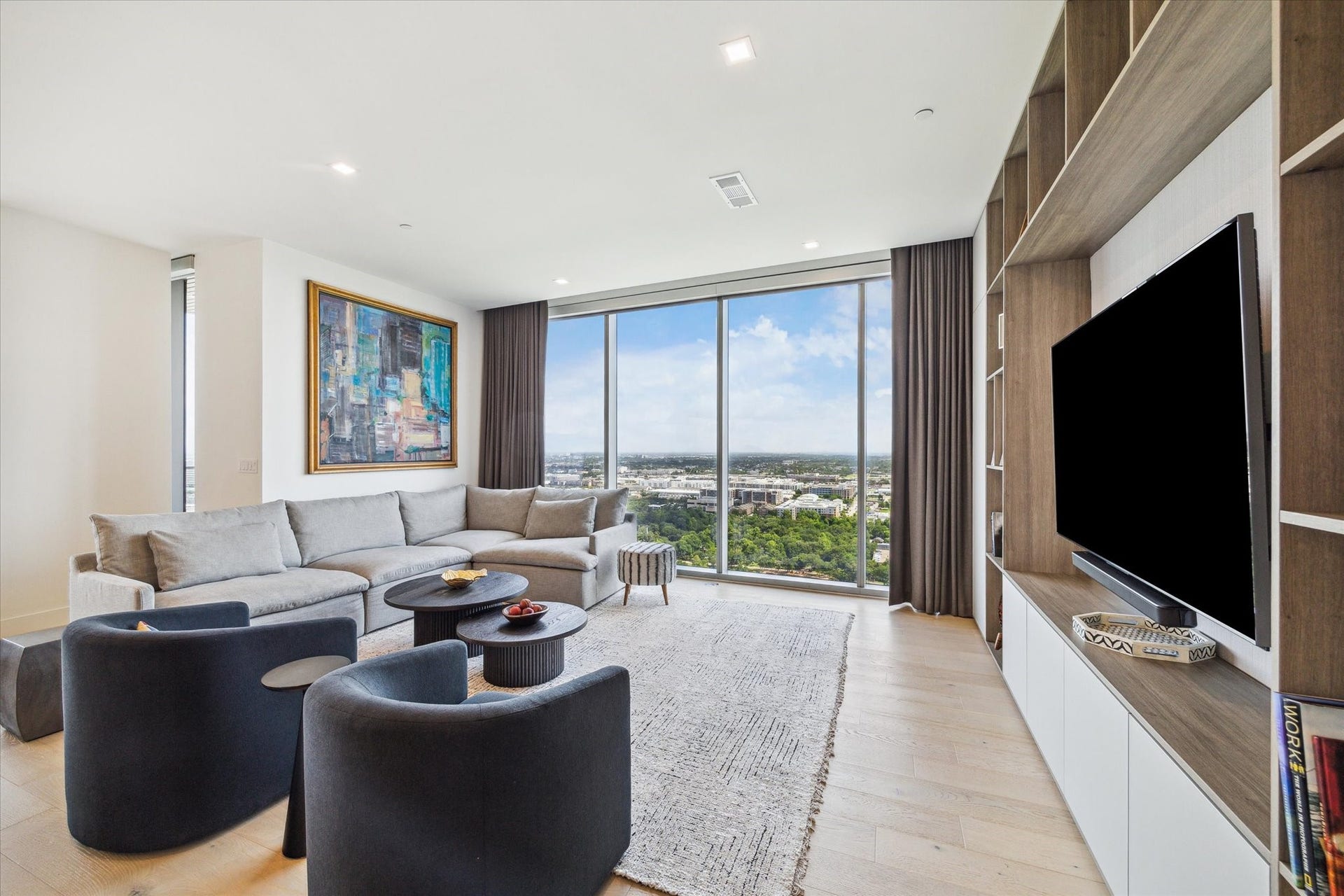 1711 Allen Parkway, #2601, Houston, TX 77019 Custom built-in shelves, cabinets, and mounted TV complement the living room.