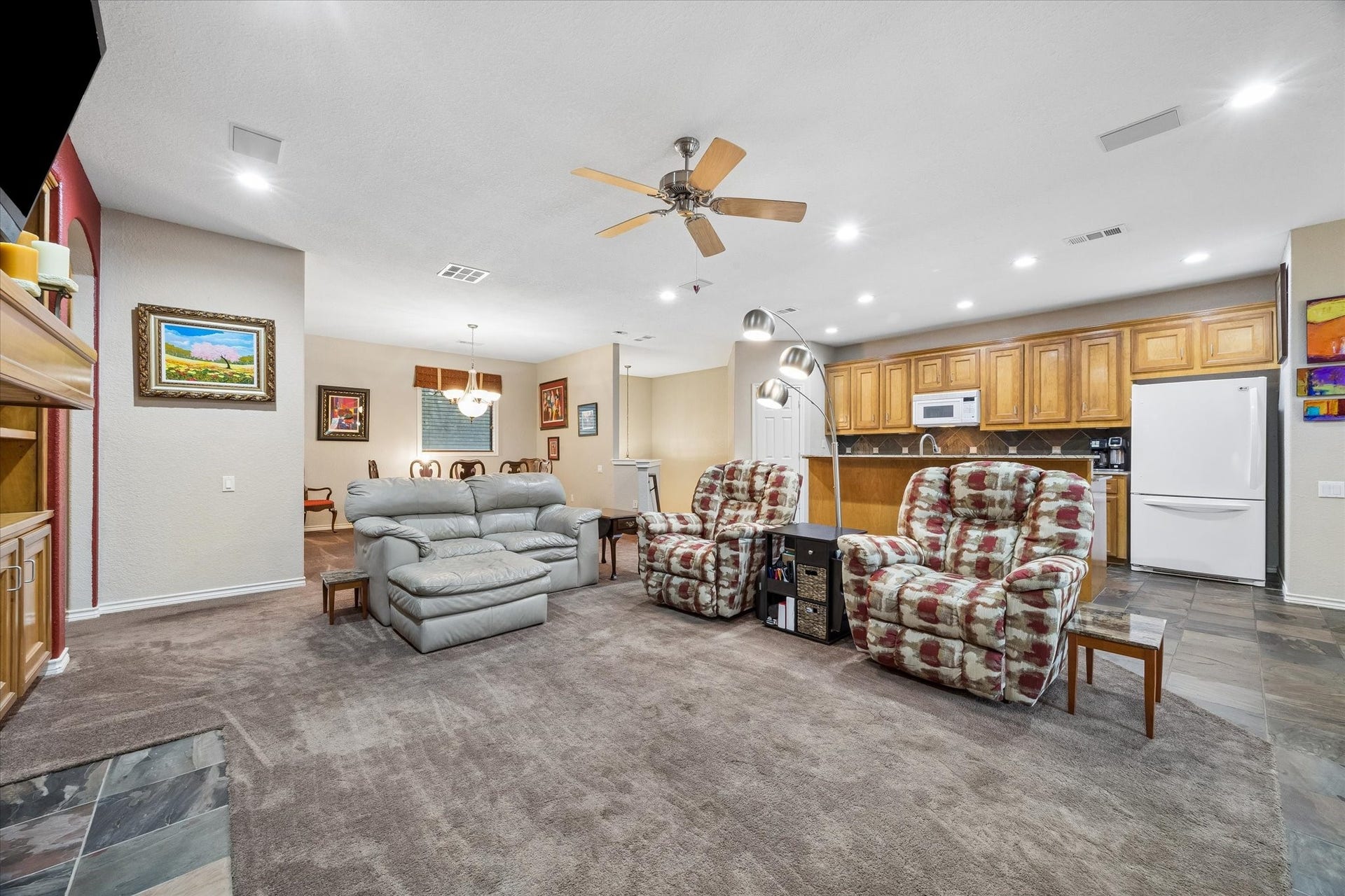 3040 Bayshore Drive, Bacliff, TX 77518 Wide-open floor plan connecting living room, dining area, and kitchen. Ample seating space with direct sightlines to the kitchen, featuring extensive cabinetry and breakfast bar for casual dining.