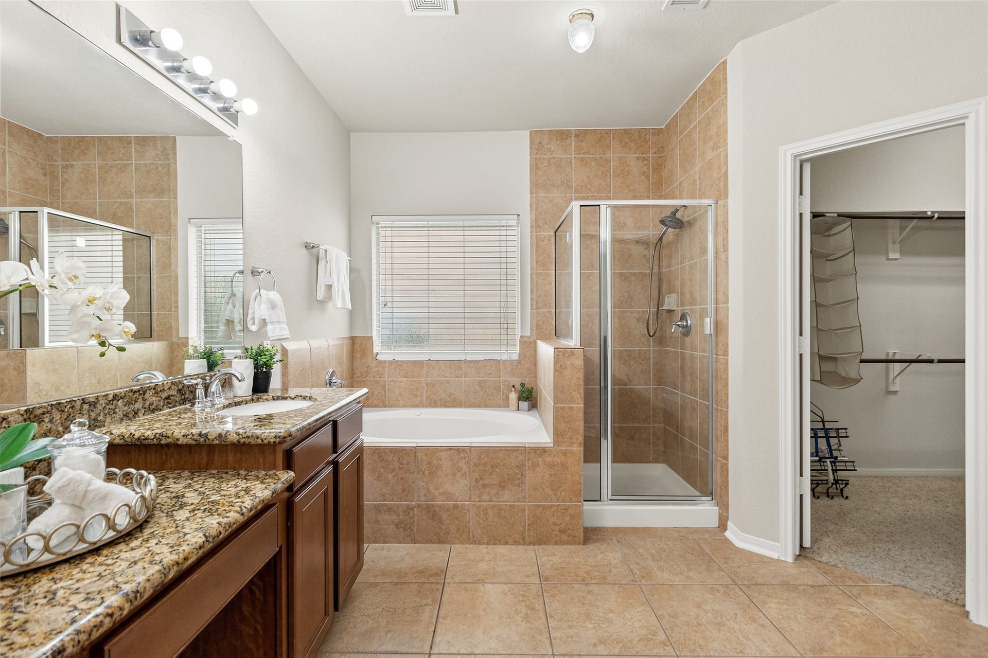 1231 Abigail Lane, Friendswood, TX 77546 Your luxurious primary bath features a soaking tub, separate glass-enclosed shower, dual vanities, and direct access to the oversized walk-in closet.