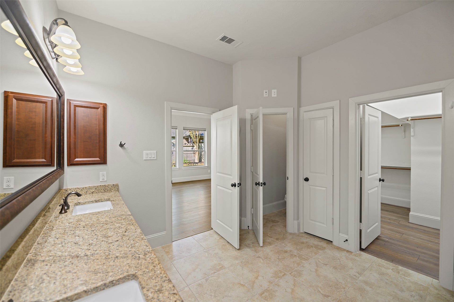 Primary bathroom with dual sinks, granite countertops and separate powder room.