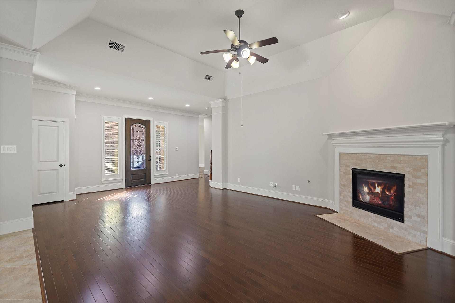 Spacious family room with high ceilings, wood floor and gas fireplace.