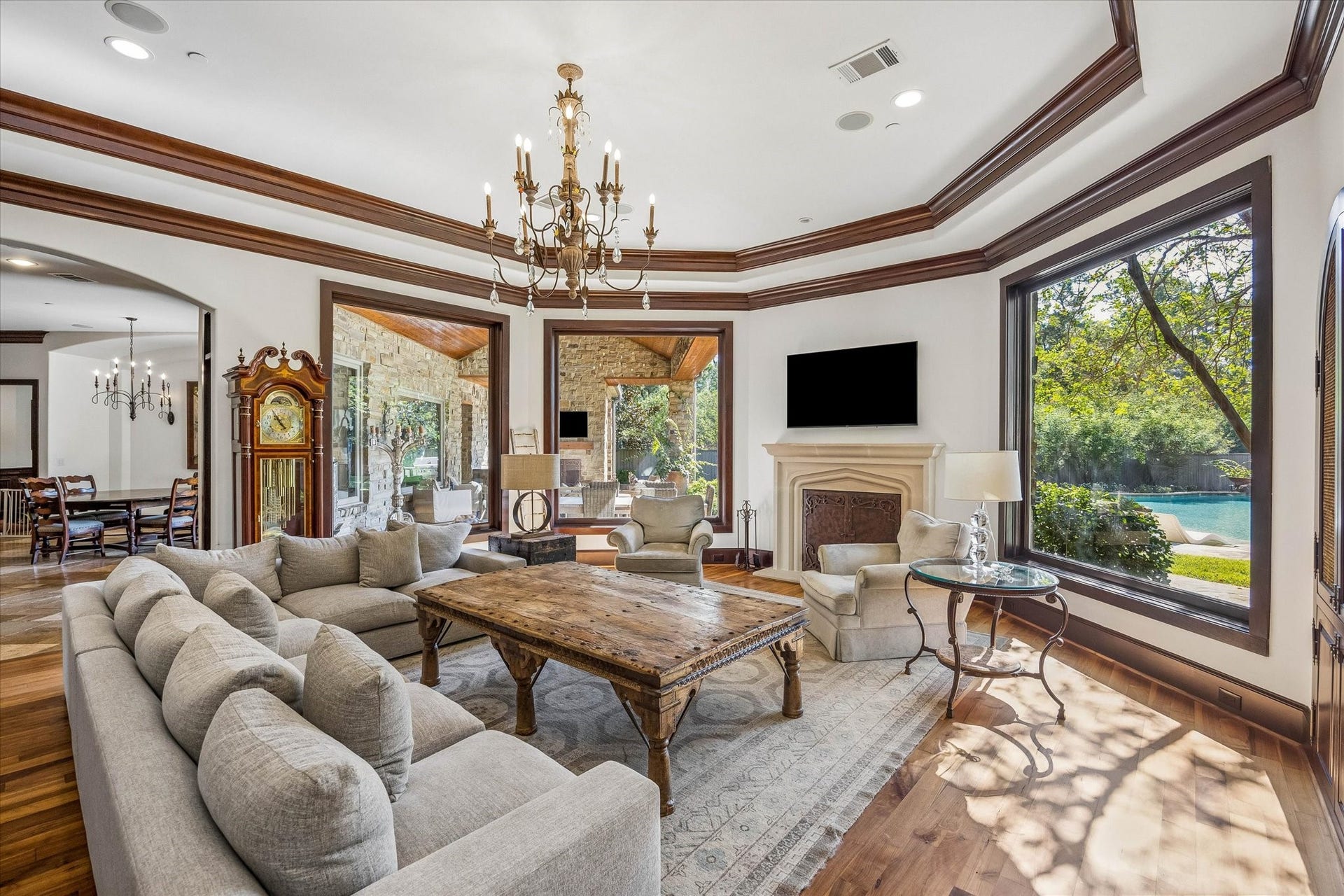 34 Liberty Bell Circle, Bunker Hill Village, TX 77024 The family room is filled with natural light from expansive windows overlooking the pool and covered patio, while a fireplace, hardwood floors, and rich wood trim add warmth and character.