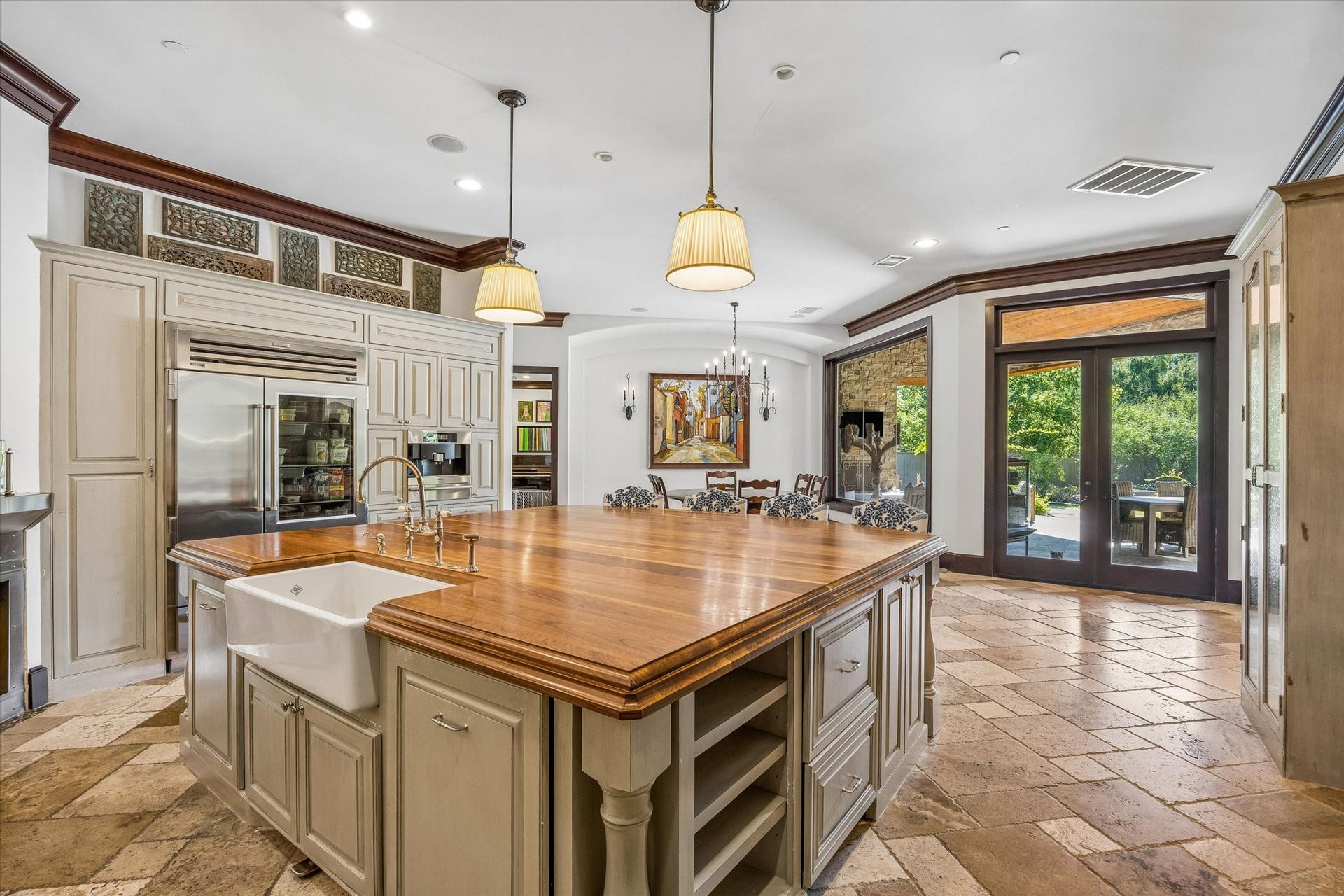 34 Liberty Bell Circle, Bunker Hill Village, TX 77024 At the heart of the kitchen, a generous wood-topped island with farmhouse sink provides ample workspace, while French doors offer easy access to the covered outdoor living area.