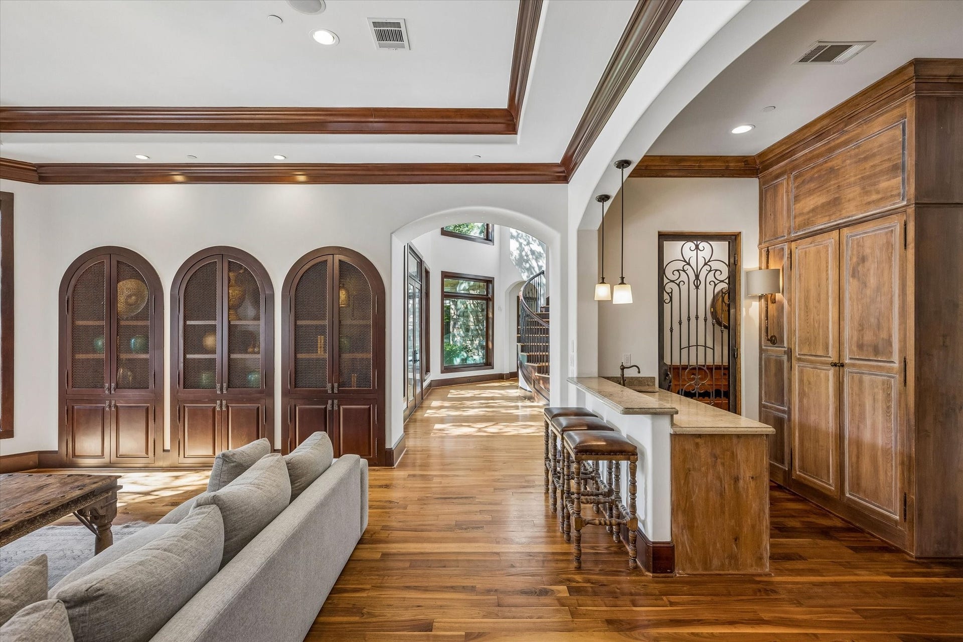 34 Liberty Bell Circle, Bunker Hill Village, TX 77024 The family room opens to a convenient wet bar with stone countertops, custom wood cabinetry, and wine storage, creating an inviting space for everyday living and entertaining.