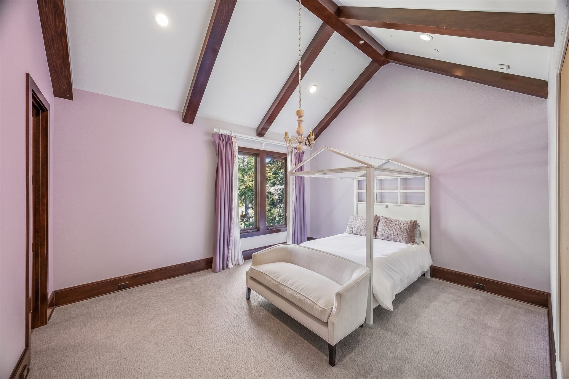 34 Liberty Bell Circle, Bunker Hill Village, TX 77024 This upstairs bedroom features a vaulted ceiling with exposed wood beams, creating a warm, inviting space with natural light and views of the surrounding trees.