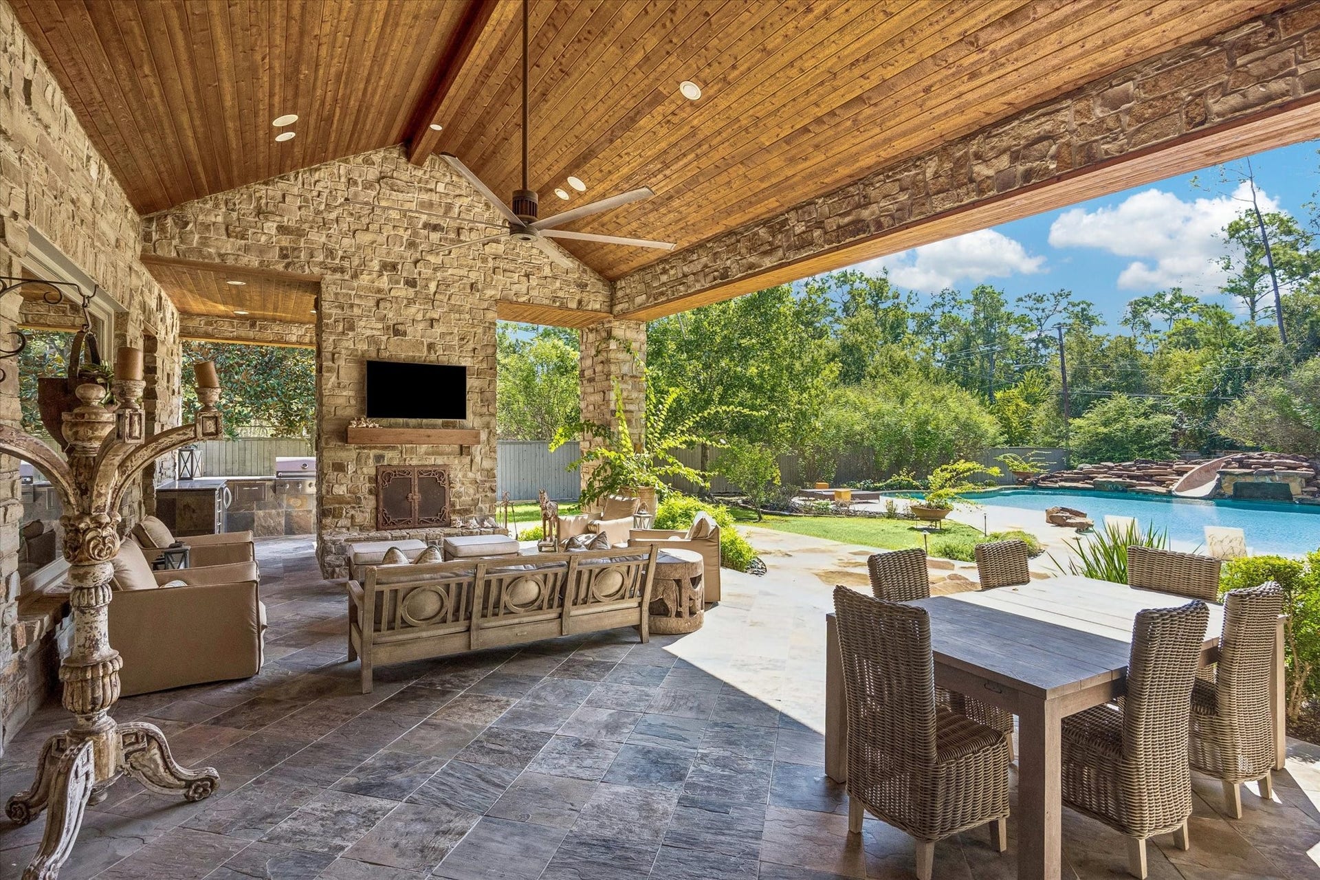 34 Liberty Bell Circle, Bunker Hill Village, TX 77024 Gather around the outdoor fireplace beneath the vaulted wood ceiling, with a spacious seating area and a fully equipped summer kitchen conveniently located on the opposite side of the fireplace.