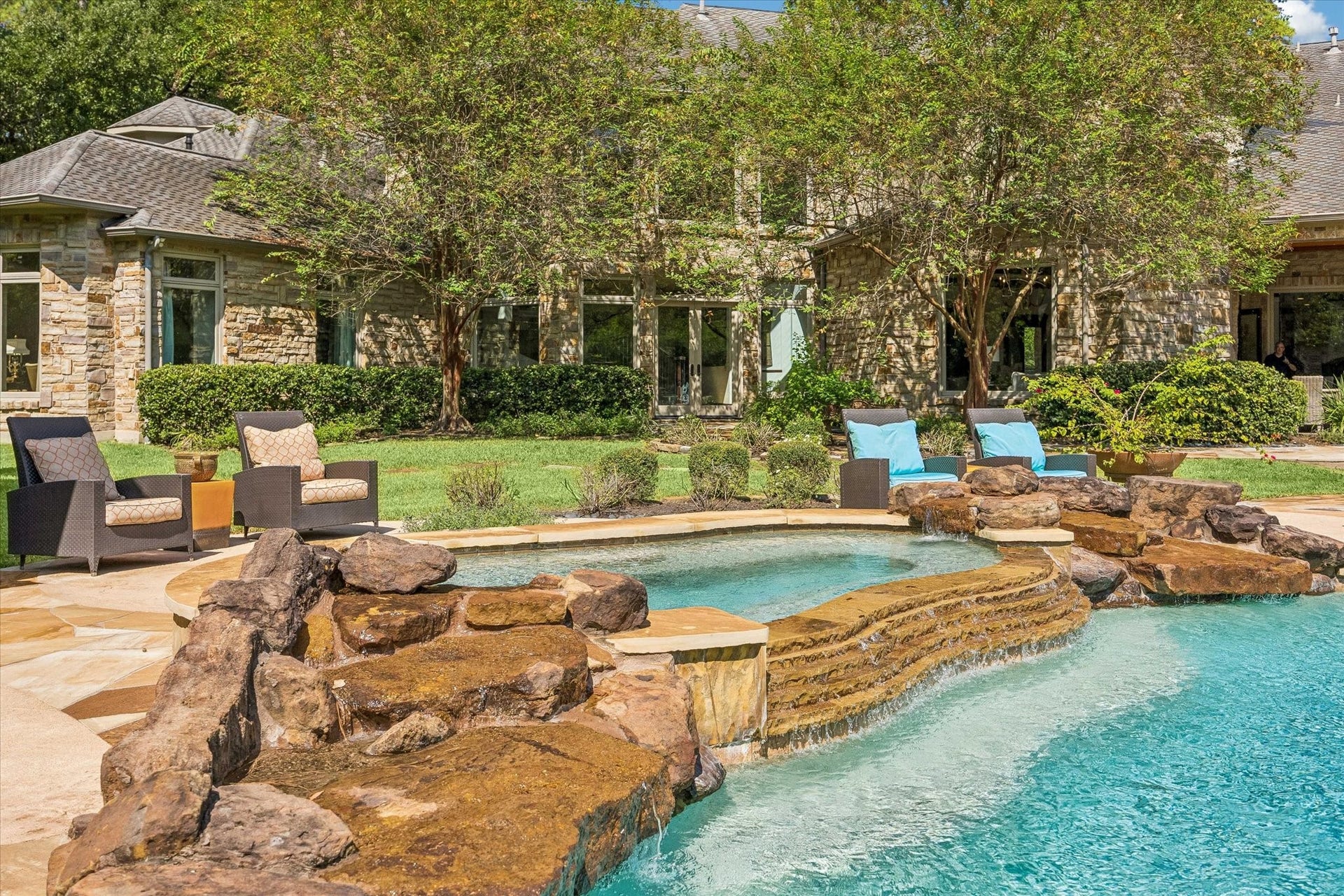 34 Liberty Bell Circle, Bunker Hill Village, TX 77024 A beautifully integrated spa with natural stone accents and a cascading spillway offers a relaxing retreat overlooking the rear of the residence.