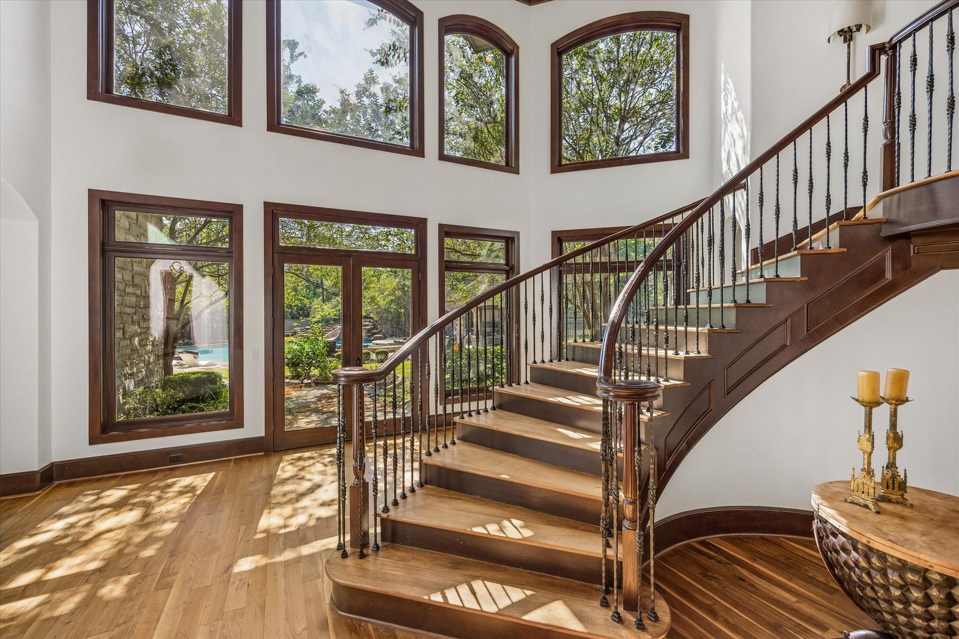 34 Liberty Bell Circle, Bunker Hill Village, TX 77024 The sweeping staircase leads upstairs, framed by soaring two-story windows that fill the entry with natural light and offer beautiful views of the backyard and pool.