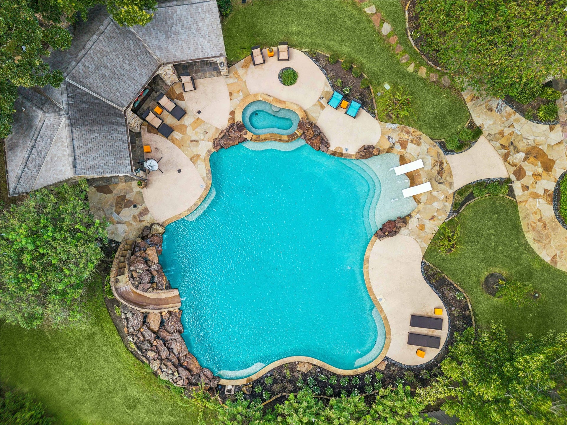 34 Liberty Bell Circle, Bunker Hill Village, TX 77024 Wow! This spectacular resort-style pool is the centerpiece of the backyard, featuring a custom waterslide, cascading waterfalls, integrated spa, sun shelf, and beautifully designed stone patios connecting to the separate outdoor pavilion.