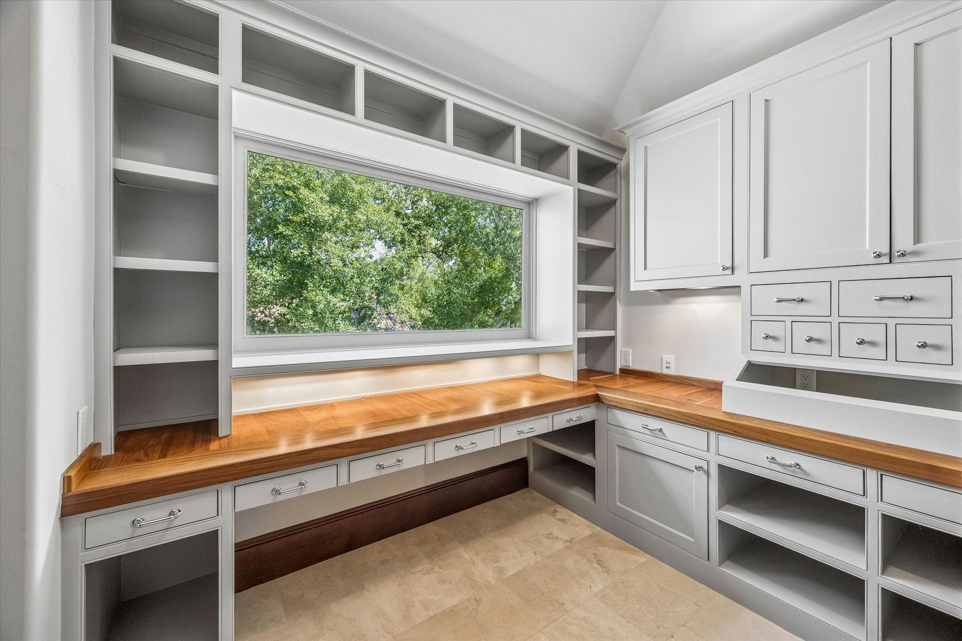 34 Liberty Bell Circle, Bunker Hill Village, TX 77024 A thoughtfully designed craft room offers abundant built-in storage, generous work surfaces, and a large window that brings natural light into the space.