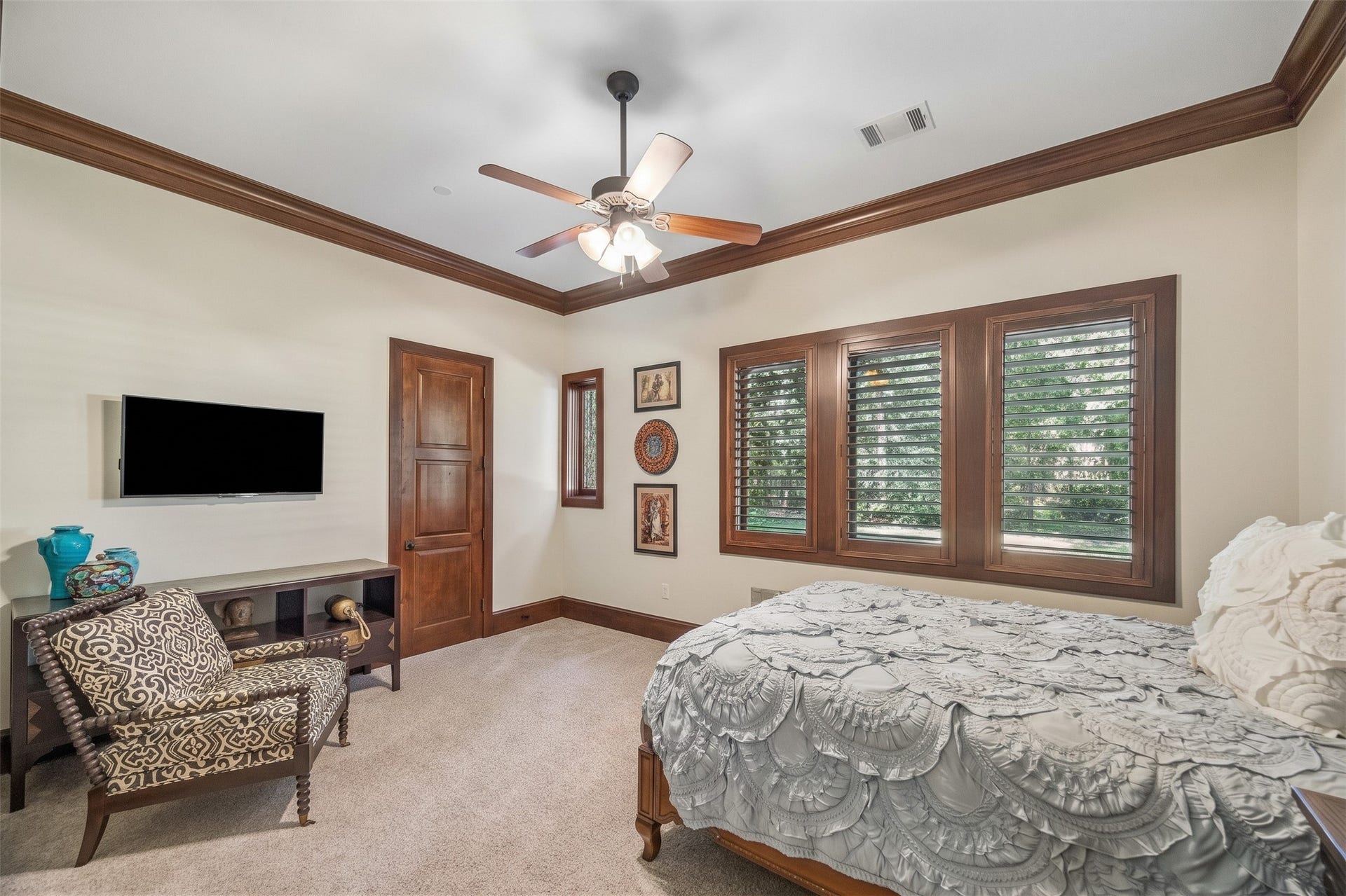 34 Liberty Bell Circle, Bunker Hill Village, TX 77024 The first-floor guest bedroom offers a comfortable retreat with generous proportions, soft carpeting, and windows with plantation shutters overlooking the grounds.