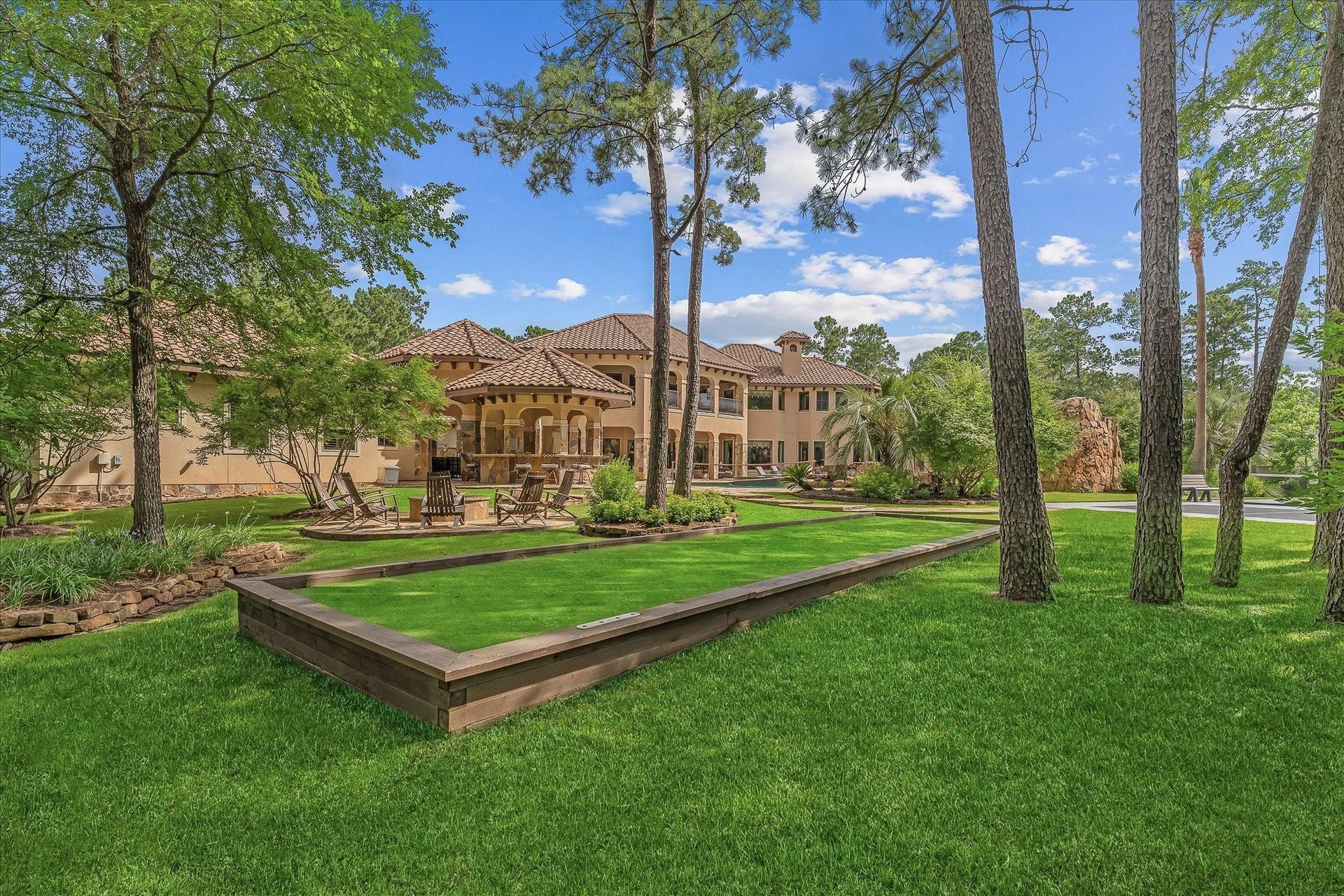 28322 Meadow Forest, Magnolia, TX 77355 Bocce ball Court next to the wood burning fire pit with seating area surrounding it.