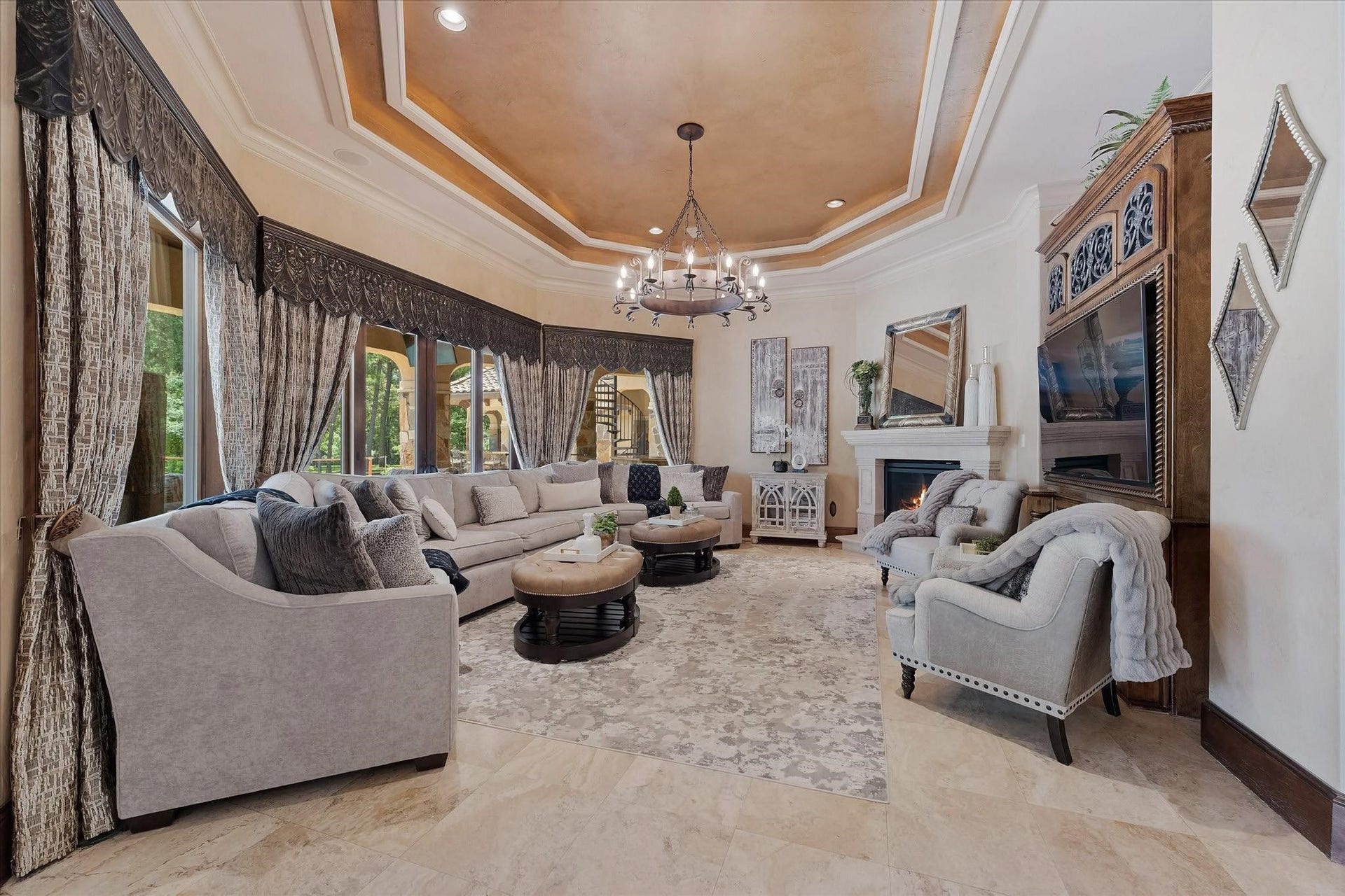 28322 Meadow Forest, Magnolia, TX 77355 Great Room with fireplace, built-in entertainment center featuring extensive millwork, large bay windows, and sliding doors. Tray ceiling with cove lighting and crown molding, recessed lighting, and surround sound speakers.