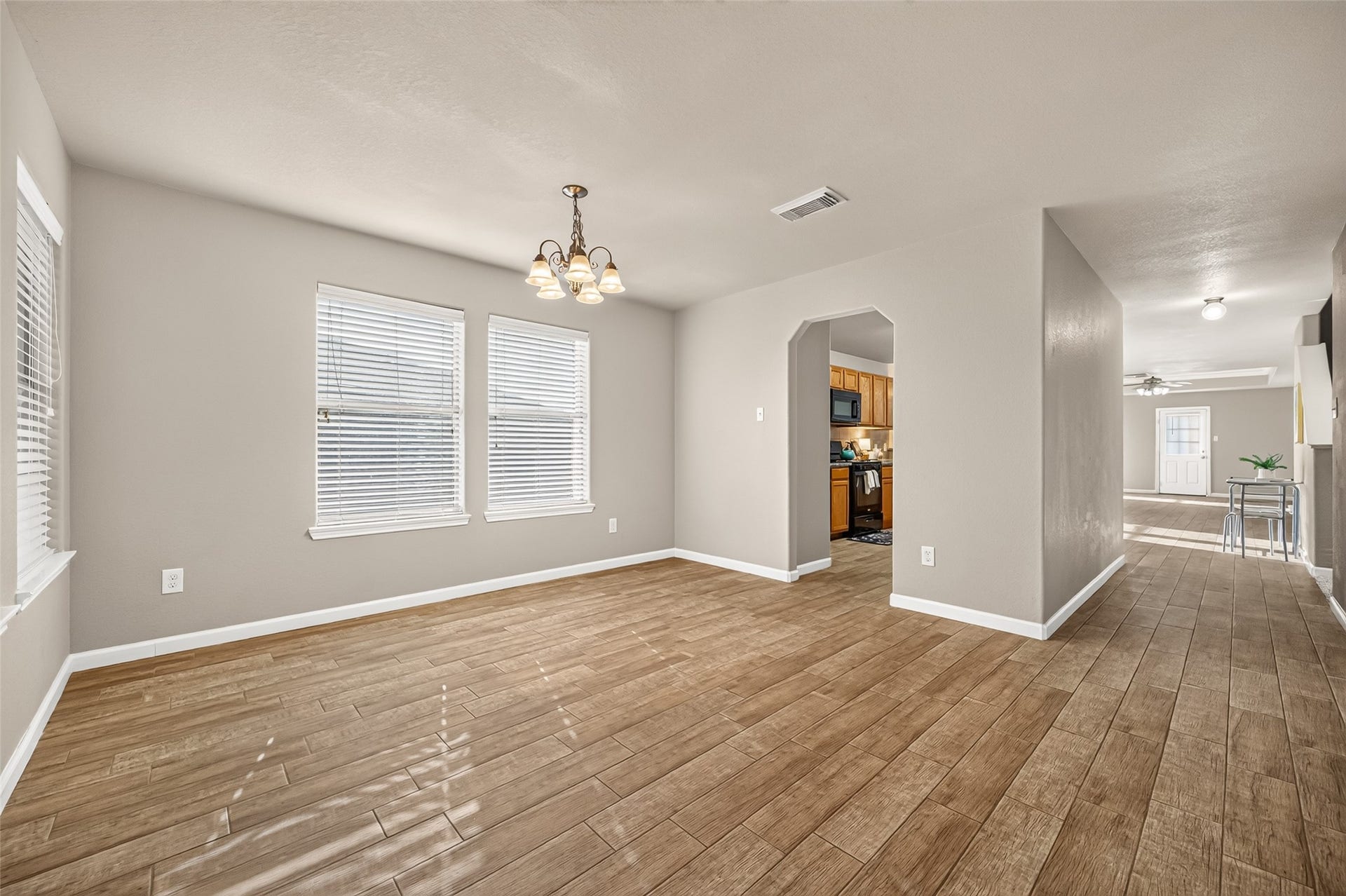 19707 Dayton Springs Drive, Cypress, TX 77429 Spacious and inviting living area with elegant tile flooring, abundant natural light from multiple windows, and a seamless flow into the kitchen and dining spaces.