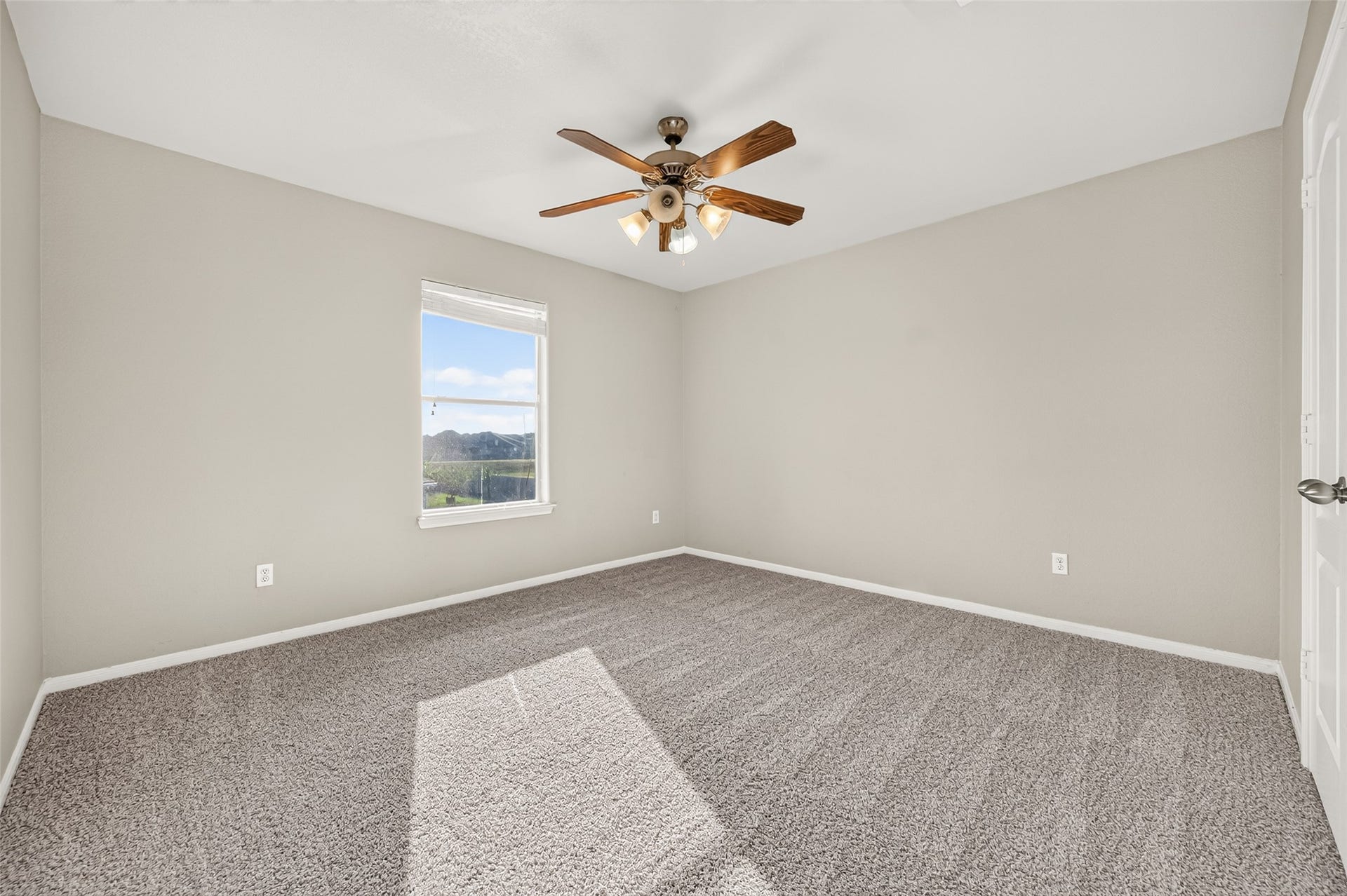 19707 Dayton Springs Drive, Cypress, TX 77429 Bright and spacious bedroom with plush carpeting, a ceiling fan, and a large window offering scenic views.