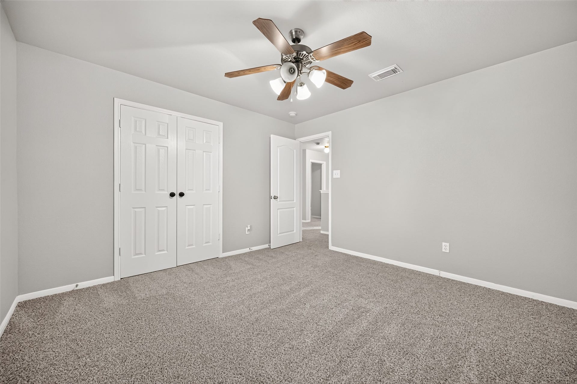 19707 Dayton Springs Drive, Cypress, TX 77429 Spacious bedroom with soft carpet, neutral walls, a ceiling fan, and ample closet space for comfortable living.