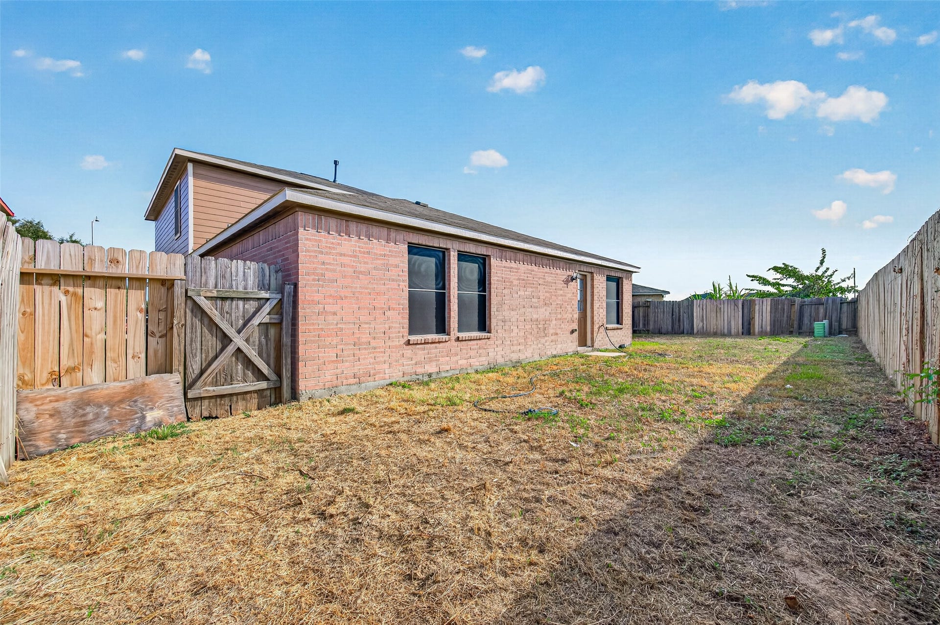19707 Dayton Springs Drive, Cypress, TX 77429 Spacious fenced backyard with brick exterior, perfect for outdoor activities and privacy.