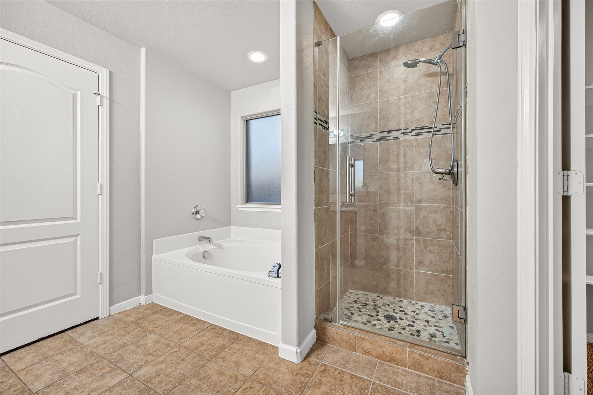19707 Dayton Springs Drive, Cypress, TX 77429 Primary bathroom featuring a spacious walk-in shower with tile work and a relaxing bathtub, complemented by neutral tones and modern fixtures.