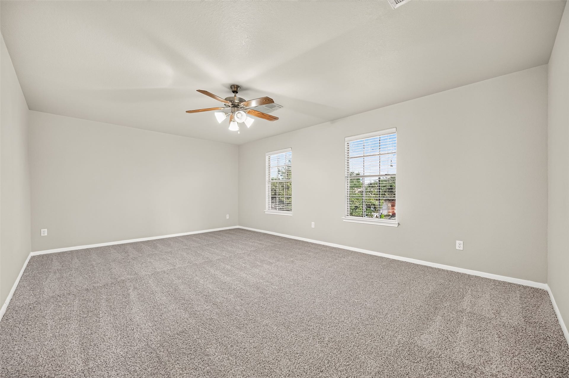 19707 Dayton Springs Drive, Cypress, TX 77429 Spacious and inviting room with plush carpeting, neutral walls, and ample natural light from two large windows, complemented by a stylish ceiling fan.
