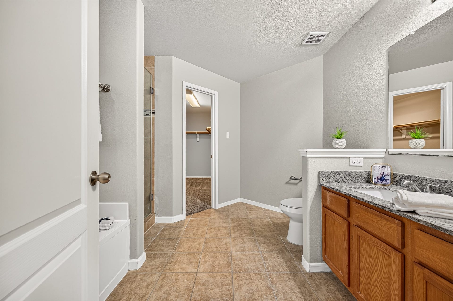 19707 Dayton Springs Drive, Cypress, TX 77429 Spacious primary bathroom featuring dual sinks with granite countertops, a separate tiled shower, and direct access to a large walk-in closet.