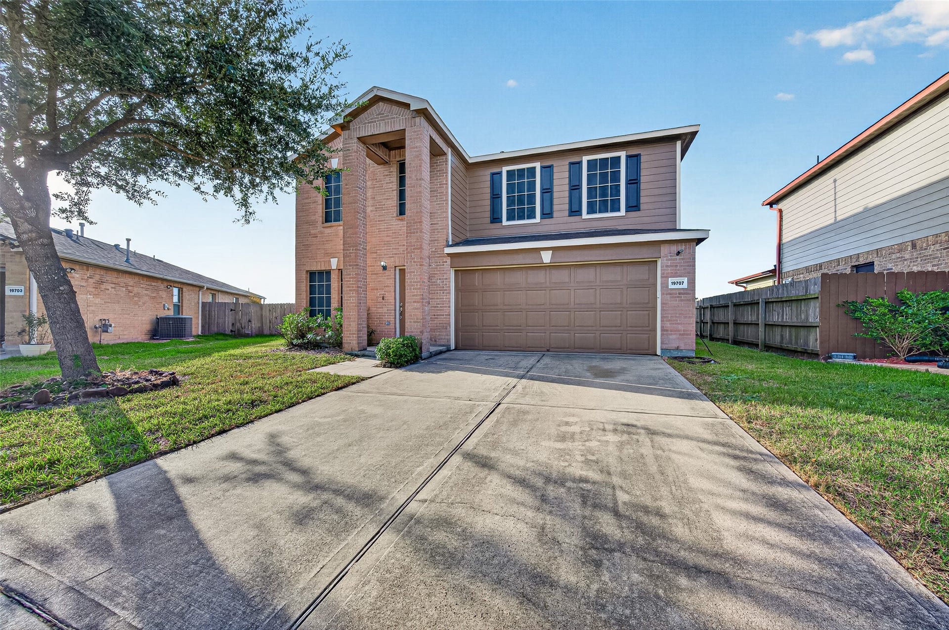 19707 Dayton Springs Drive, Cypress, TX 77429 Charming two-story home with a brick and siding exterior, featuring a spacious driveway and an attached two-car garage.