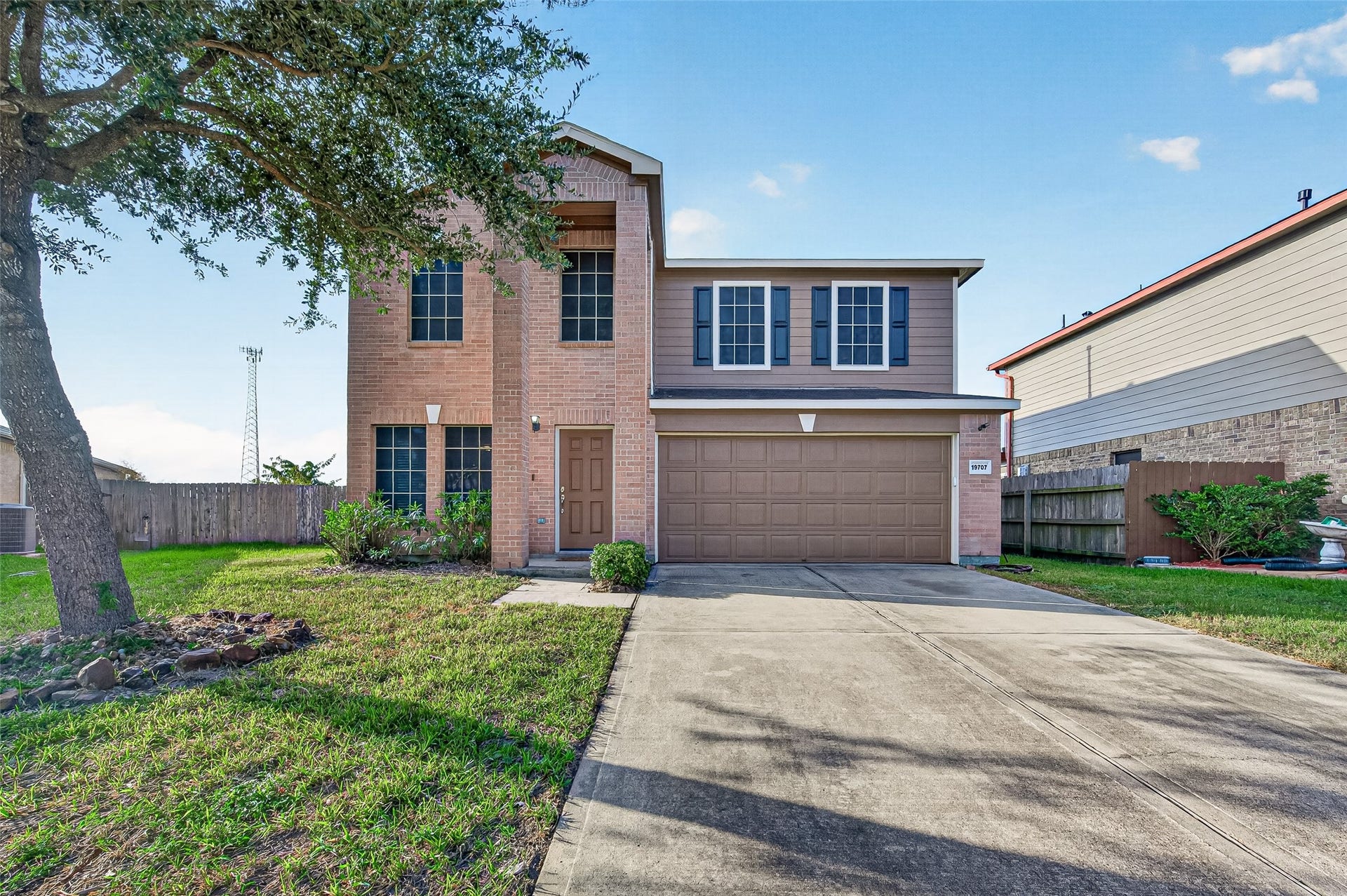 19707 Dayton Springs Drive, Cypress, TX 77429 Charming two-story brick home with a spacious driveway and a two-car garage, nestled in a serene neighborhood.