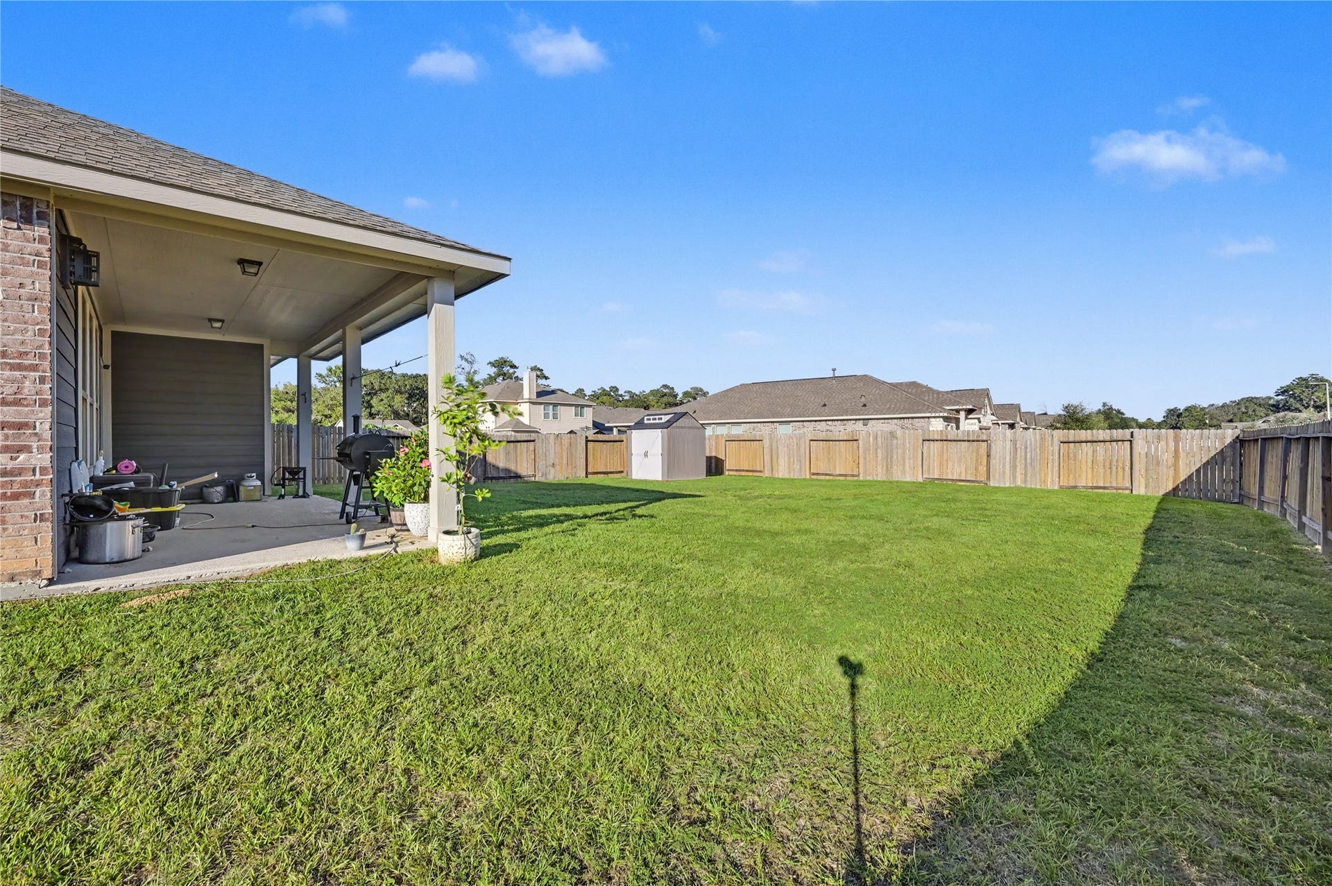 Step outside to a spacious covered patio overlooking the beautiful backyard. This inviting outdoor area offers a great place to enjoy morning coffee, entertain guests, or unwind while taking in the peaceful surroundings.
