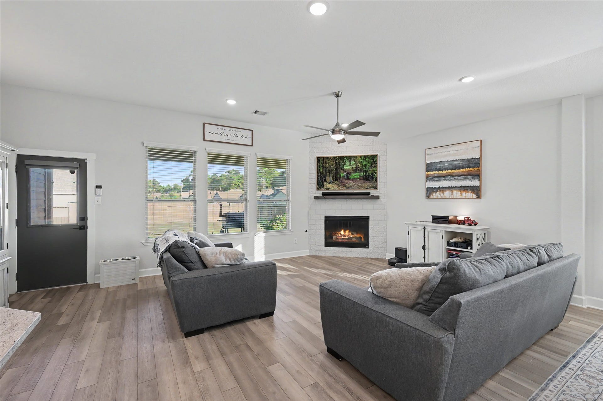 This bright and airy living space showcases the home's open floor plan and generous gathering areas. Large windows invite natural light inside, while the spacious layout offers flexibility for furniture arrangements and everyday comfort.