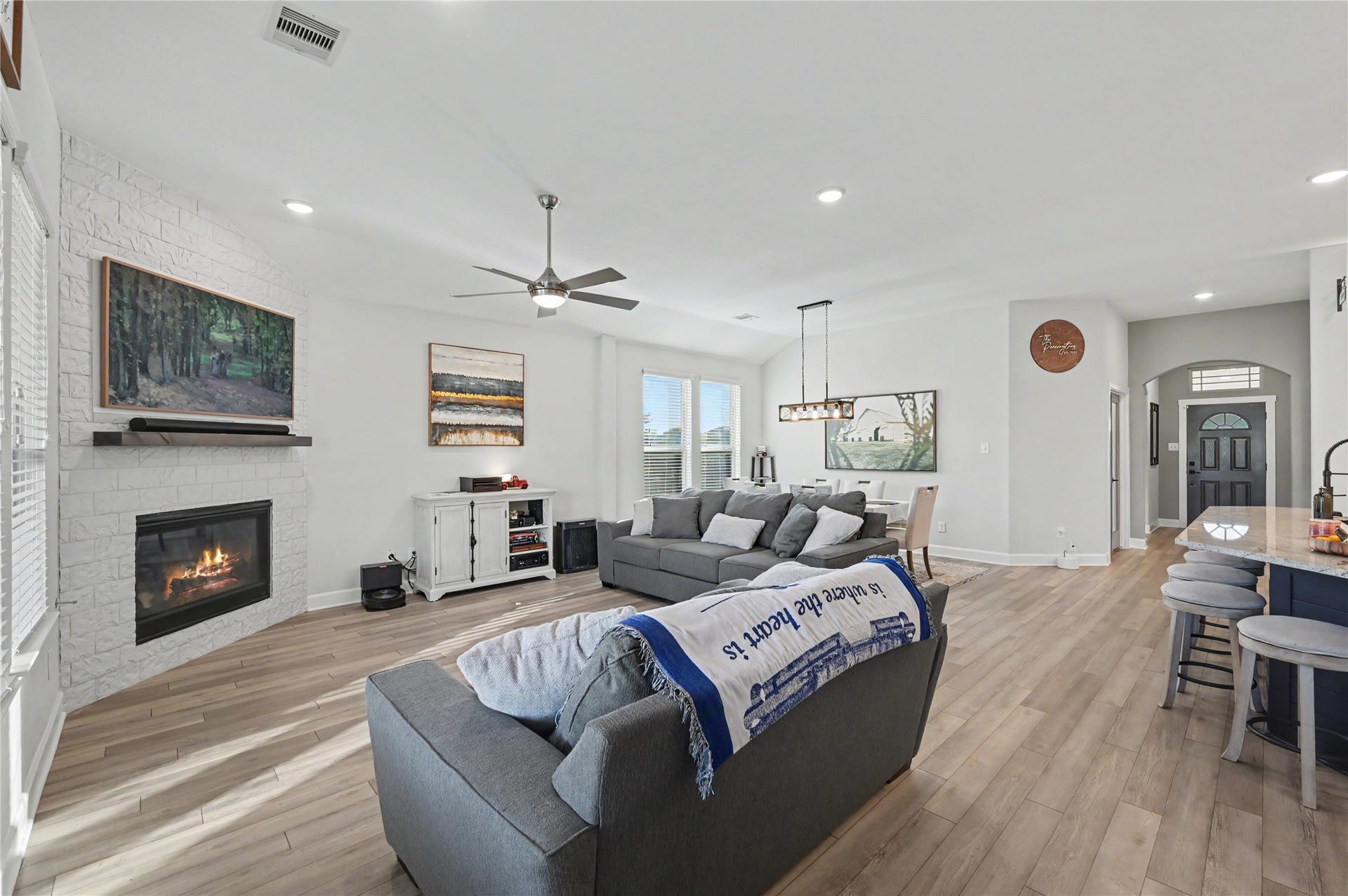 The beautifully appointed living room features a stylish fireplace that serves as an attractive focal point. With its open layout, neutral finishes, and comfortable atmosphere, this space offers a wonderful setting for relaxing or entertaining guests.