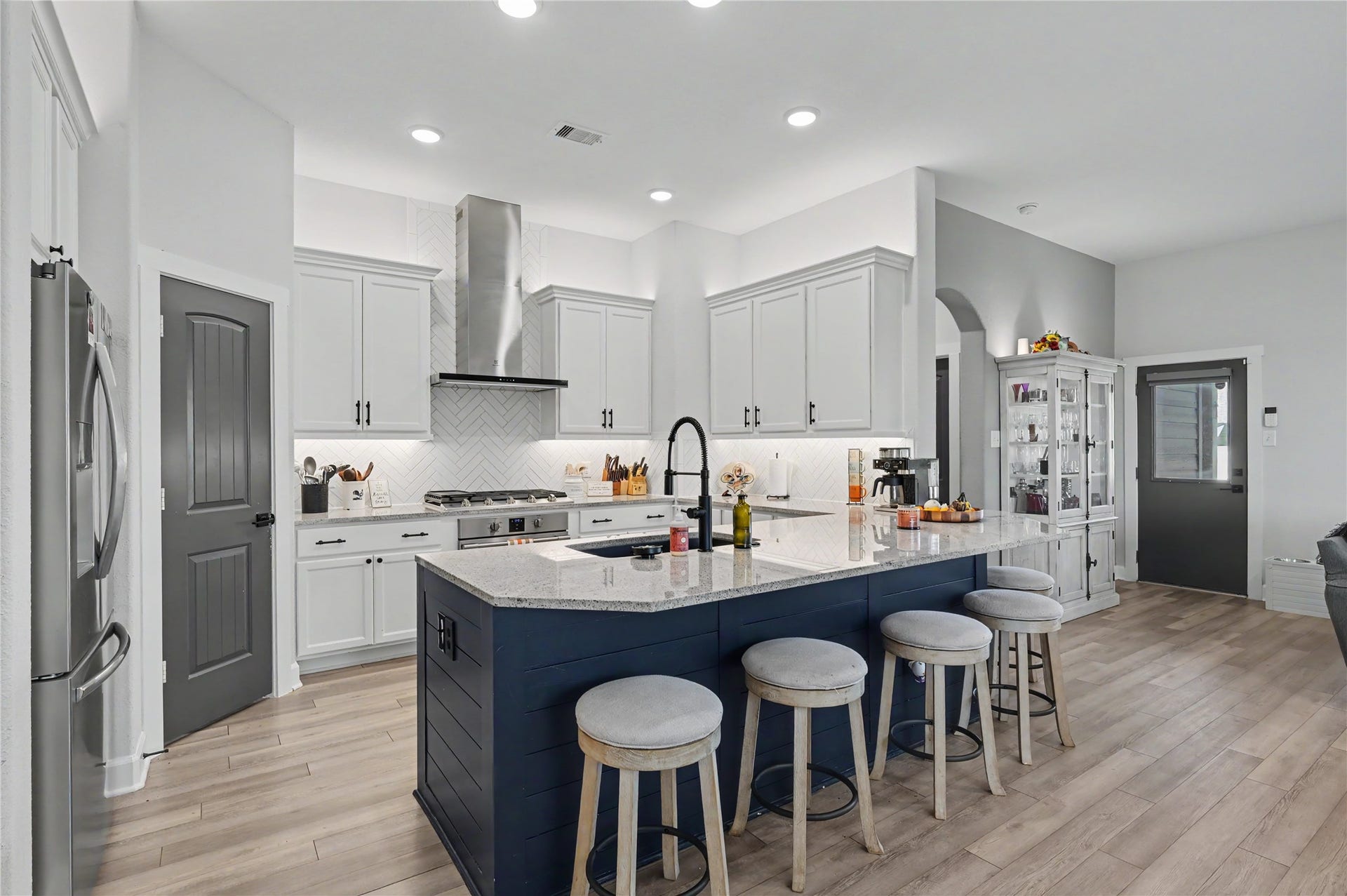 This gorgeous kitchen is designed with both style and functionality in mind, featuring a spacious center island, beautiful cabinetry, and elegant pendant lighting. The open layout provides generous room for meal preparation, casual dining, and gathering with family or guests.
